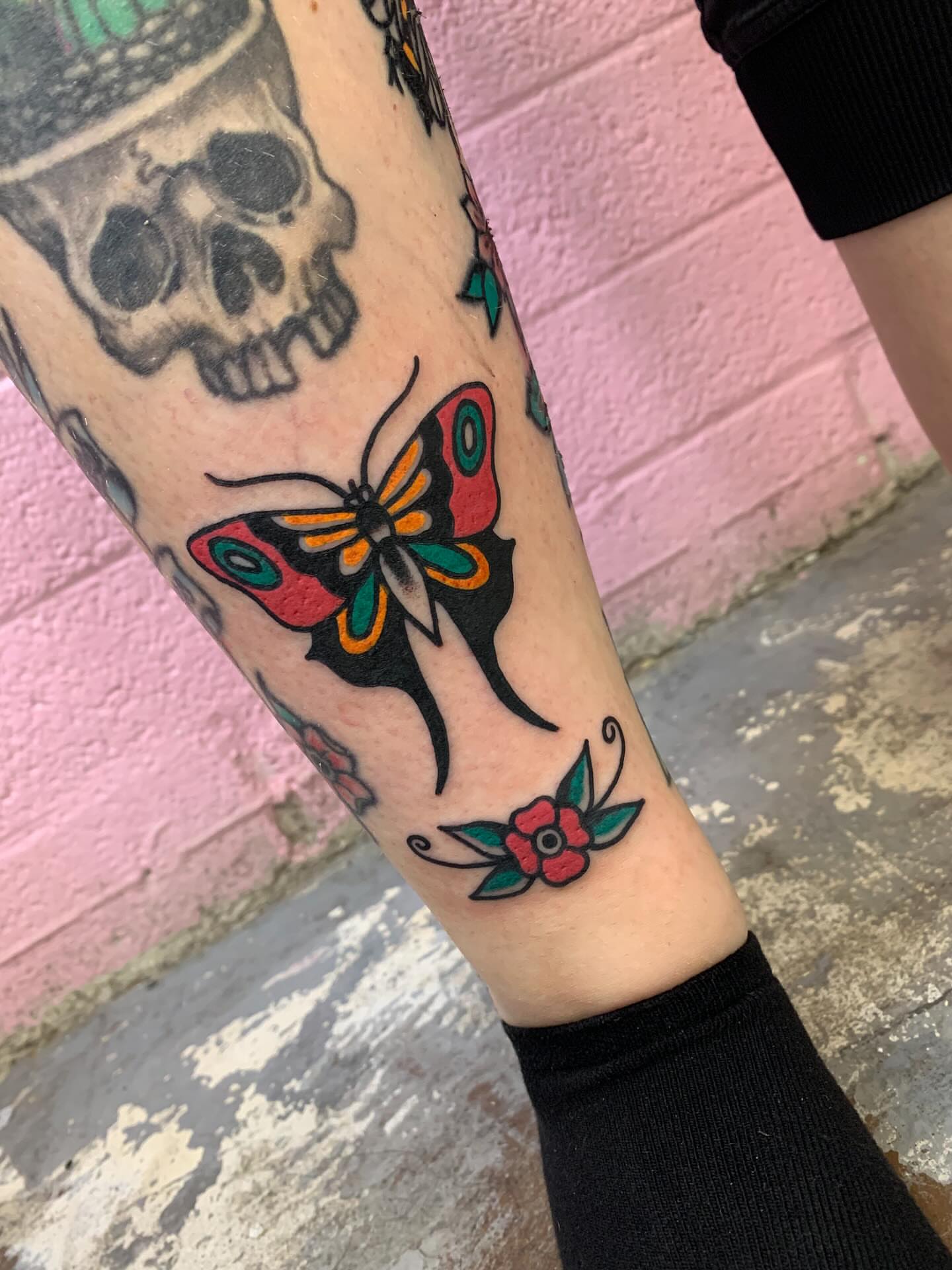 Butterfly and flower American traditional tattoo on the forearm by Chrissie