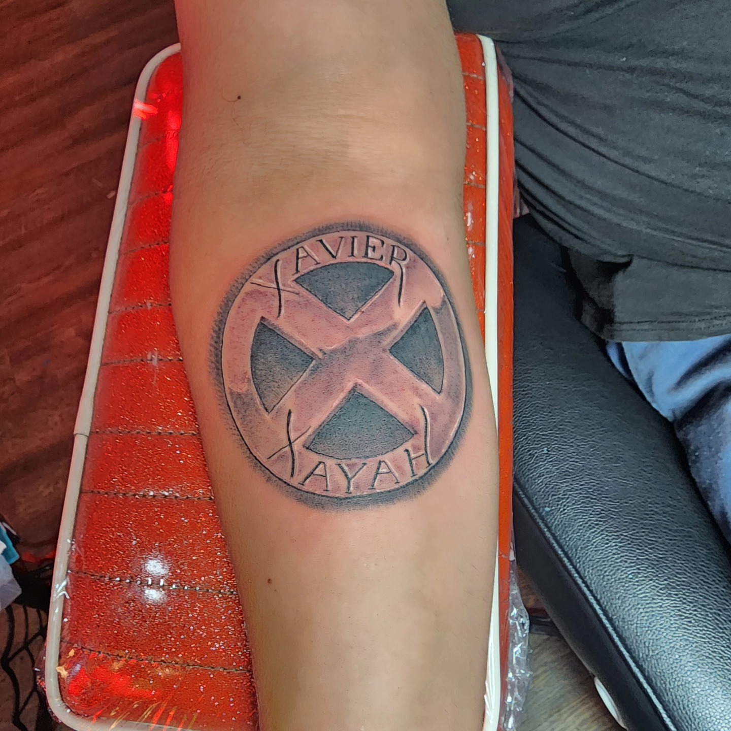 Xavier Xayah symbol black and grey tattoo on the forearm by Joe Garcia