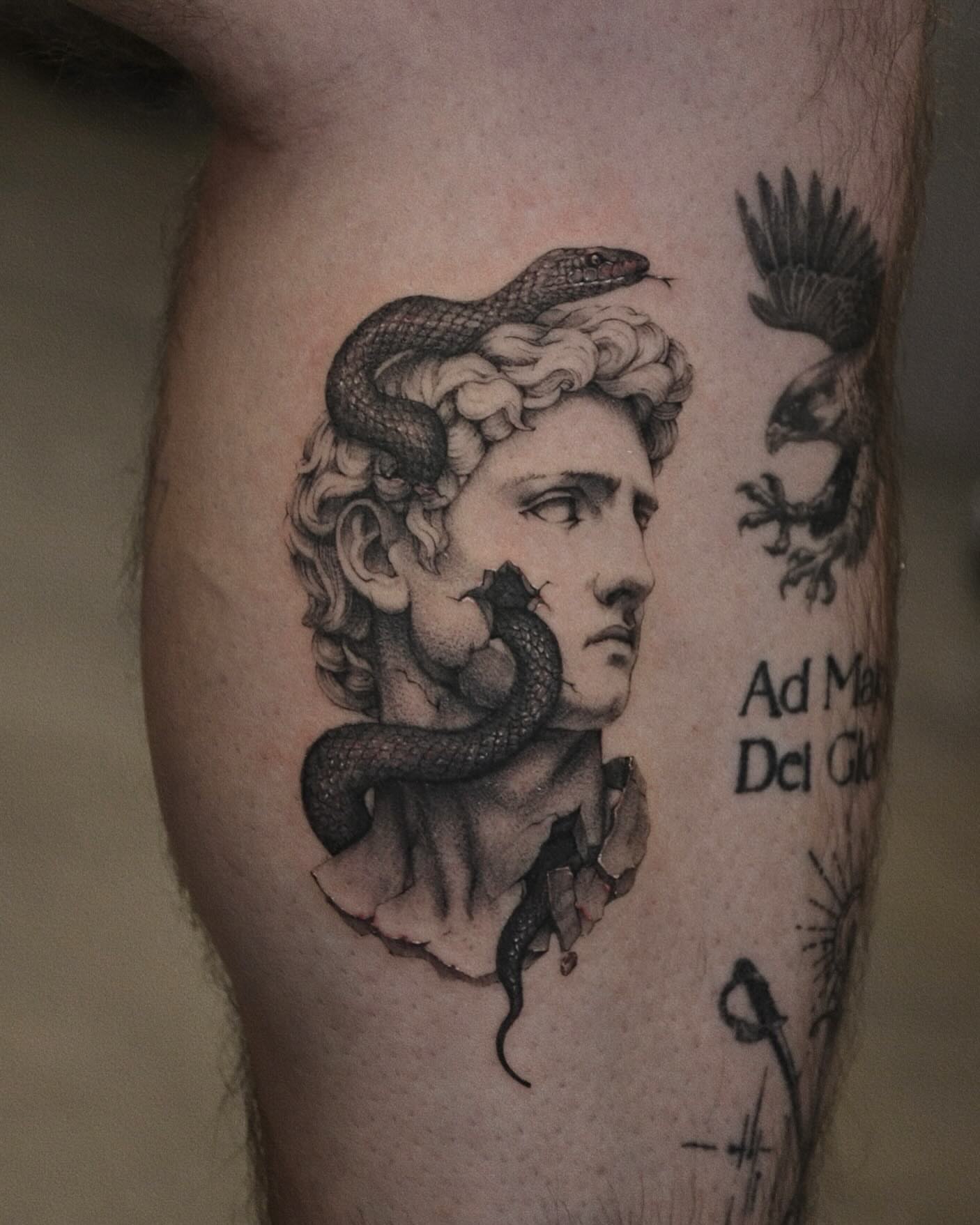 Statue head with snake realism tattoo on the thigh by Gary Zhong, Upland, California