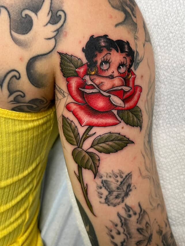Betty Boop in rose American traditional tattoo on the forearm by Valerie Dominguez