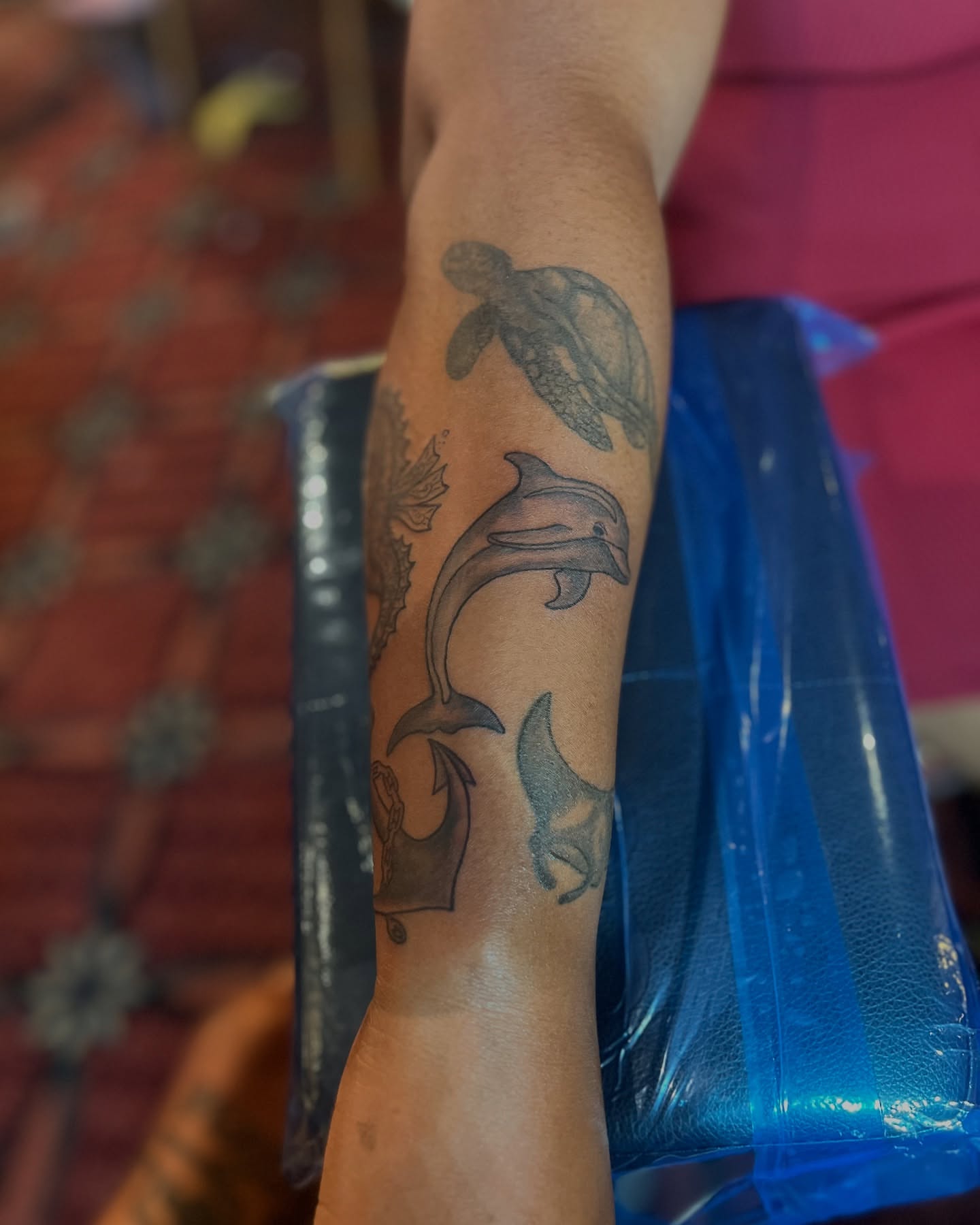 Dolphins and turtle black and grey tattoo on the forearm by CandiCoatedInk