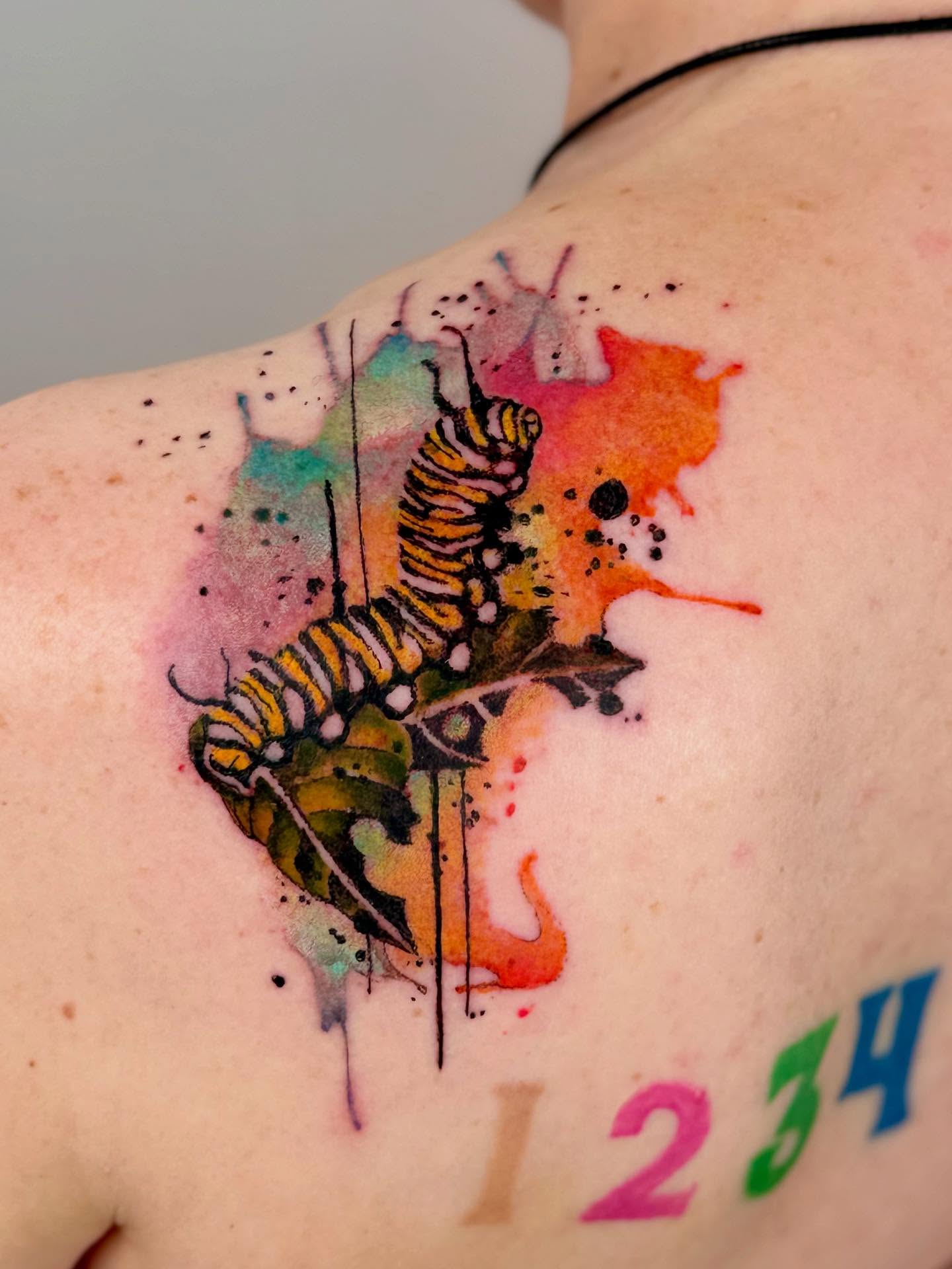 Monarch caterpillar watercolor tattoo on the shoulder by Gene Coffey, New York, New York