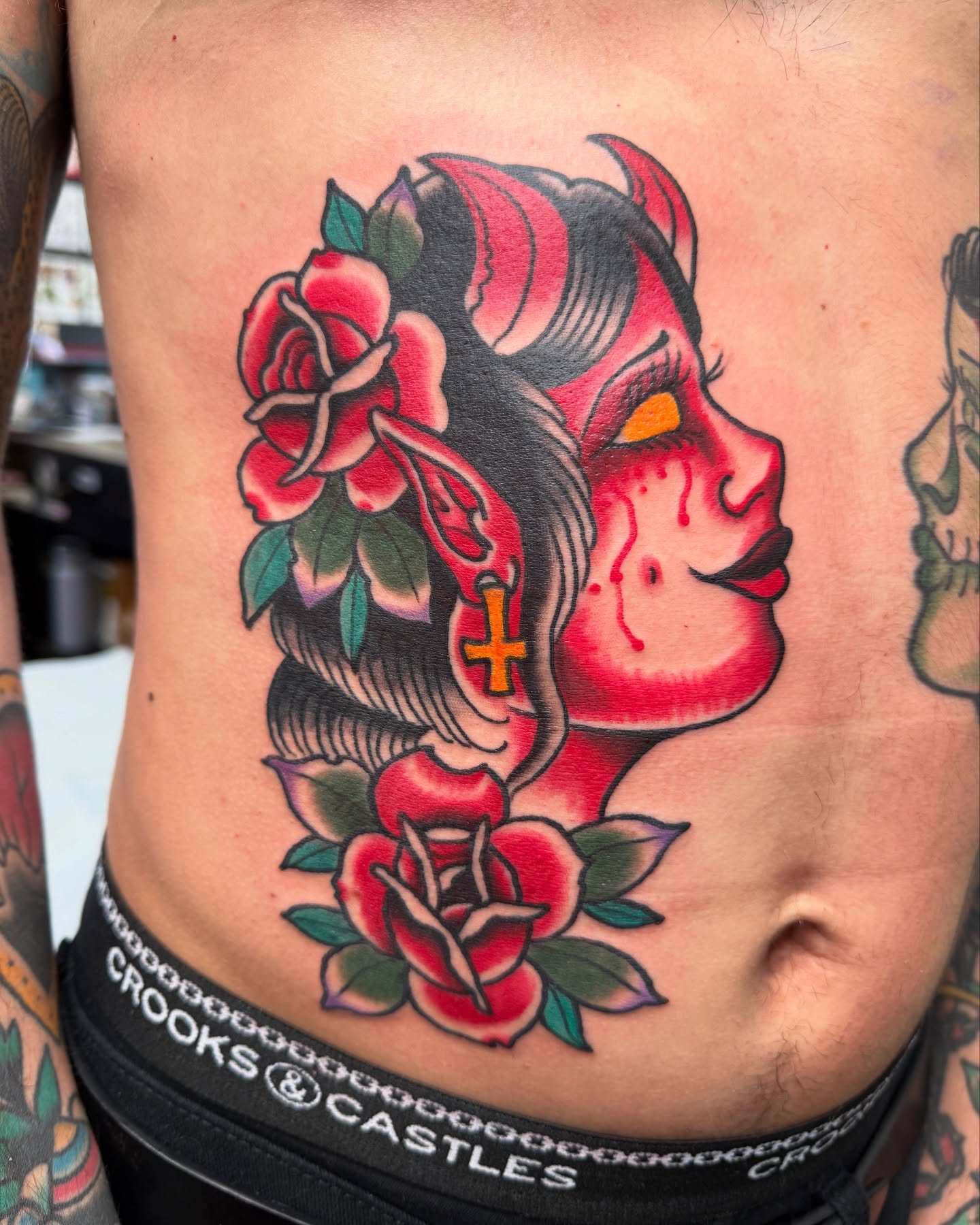 Woman's face with roses American traditional tattoo on the ribs by DemianThompson