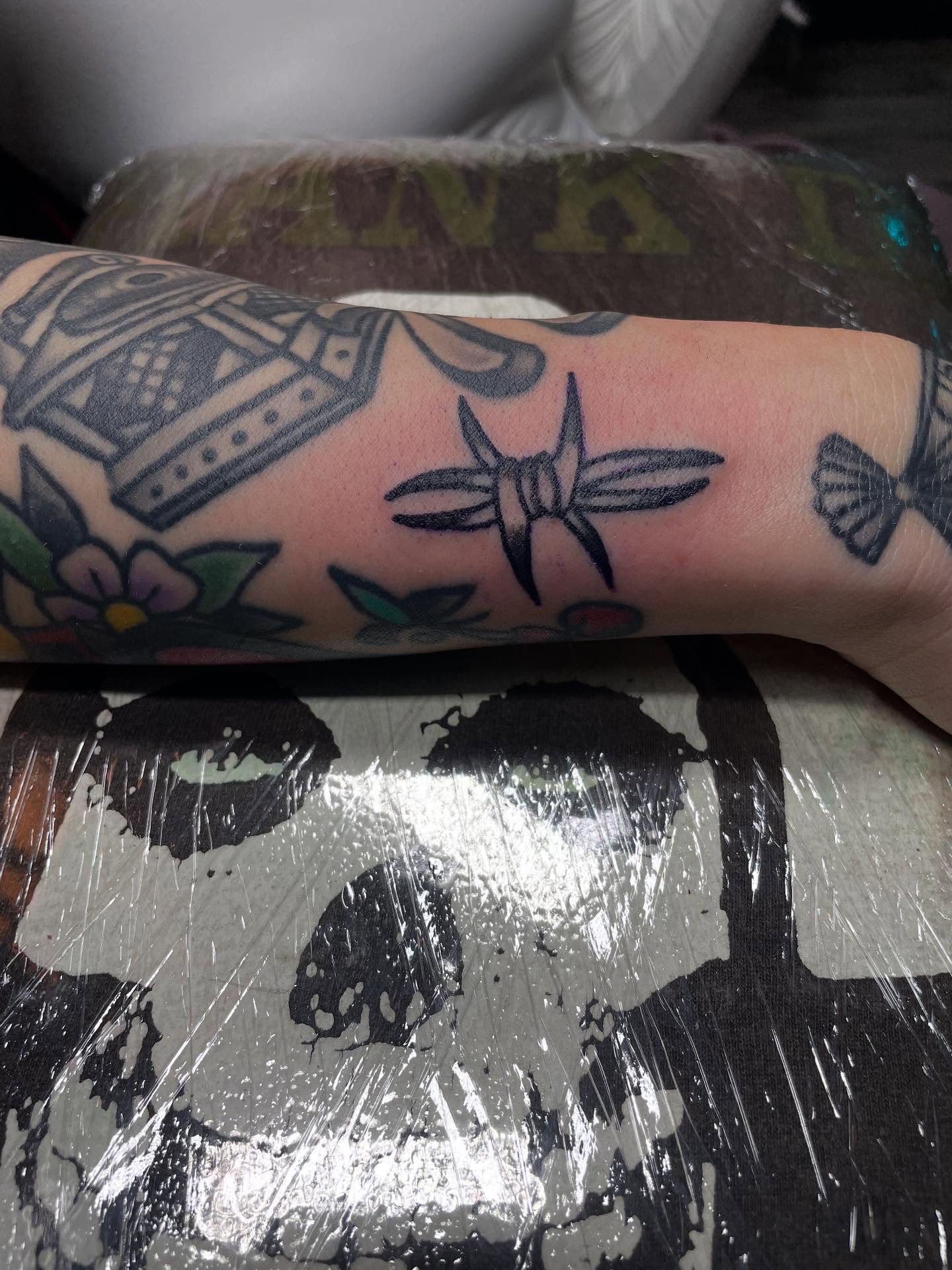 Dragonfly and floral American traditional tattoo on the forearm by Mark Johnson [Tattoo Artist]