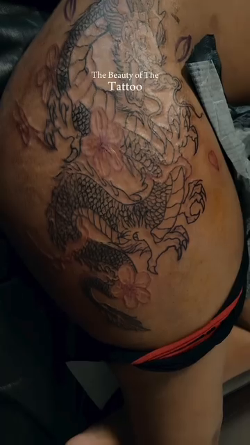 Dragon and cherry blossoms Japanese tattoo on the thigh by Lopez Dautruche