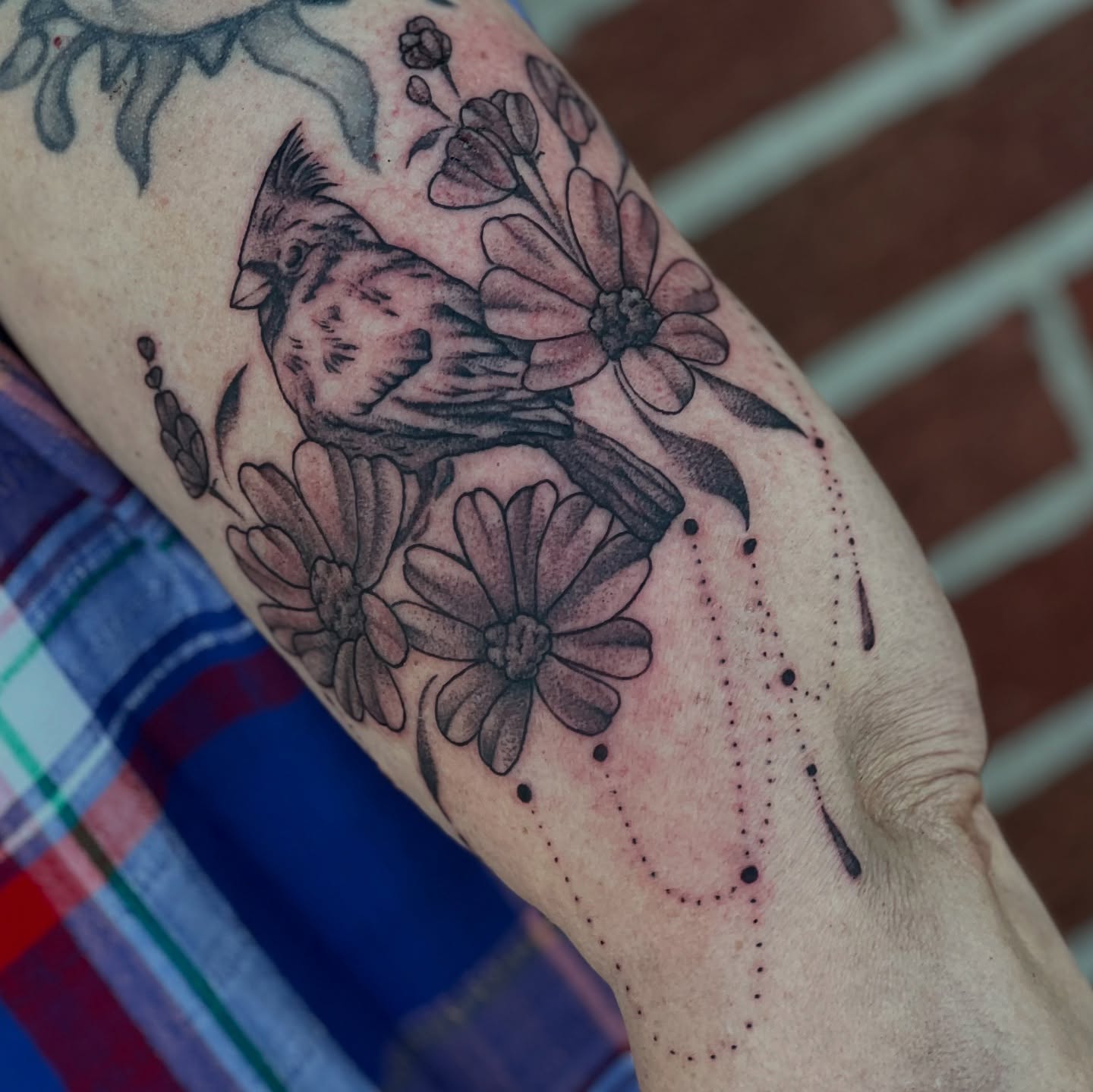 Bird and flowers black and grey tattoo on the forearm by Dani McBay