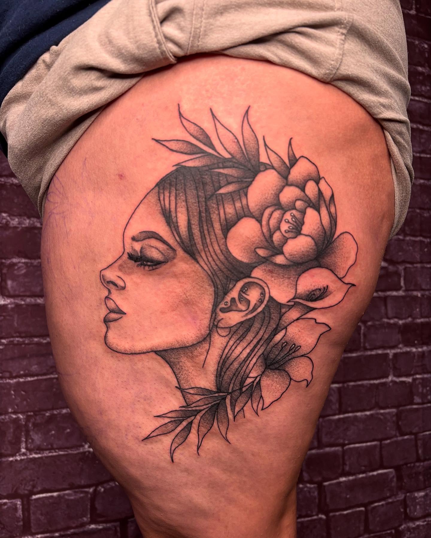 Woman with flowers realism tattoo on the thigh by kylie