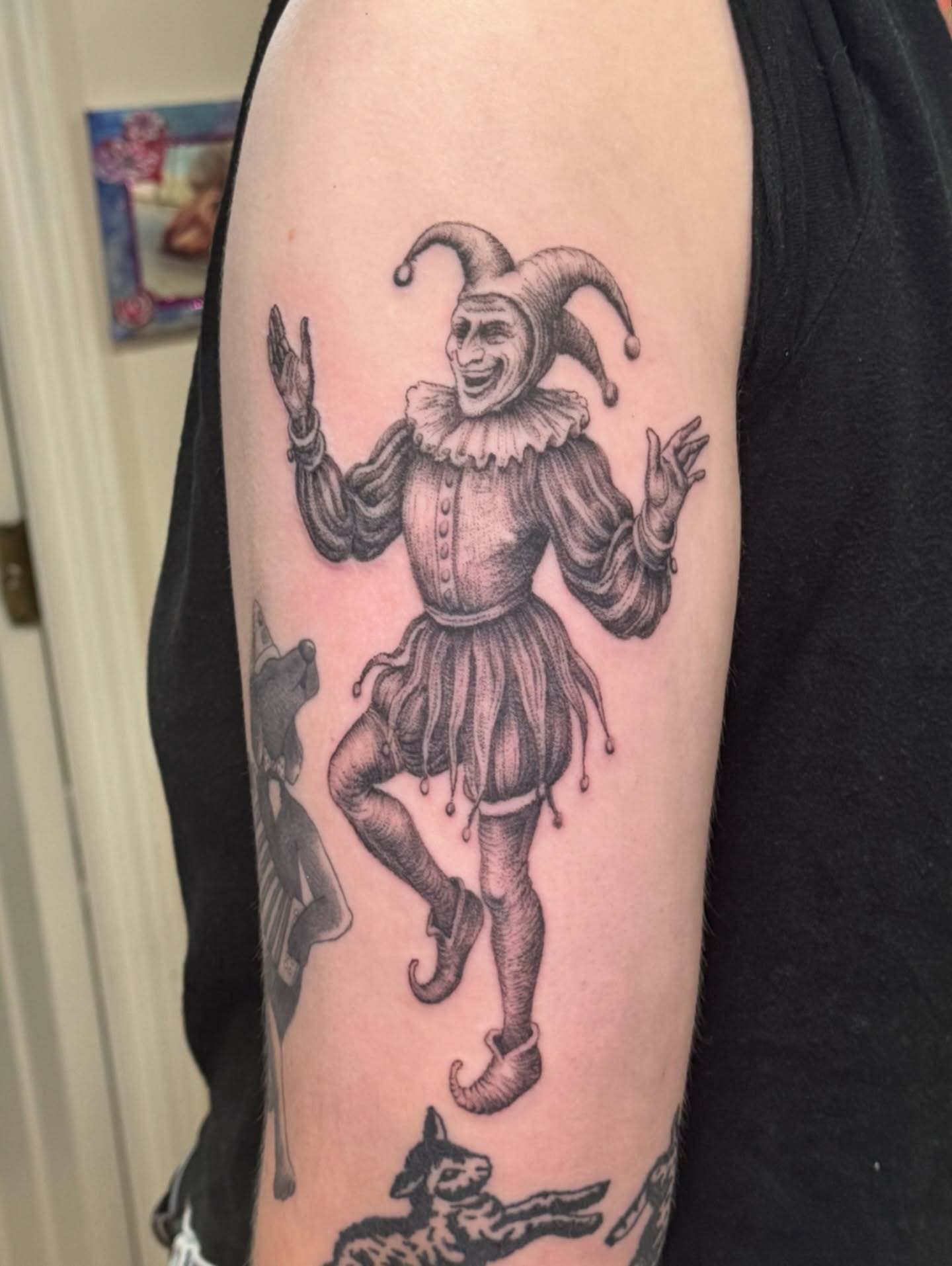 Jester black and grey tattoo on the forearm by William Worley