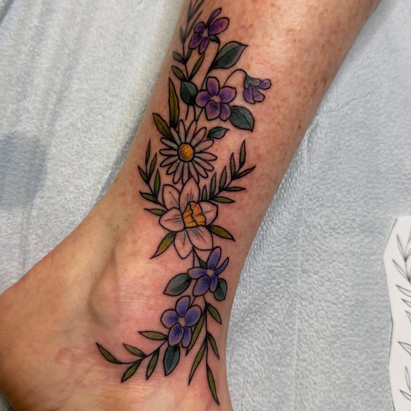 Floral arrangement American traditional tattoo on the forearm by Nikki Powills