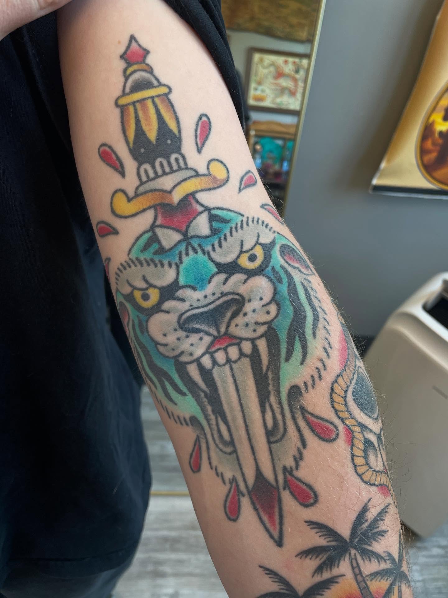 Lion and dagger American traditional tattoo on the forearm by Josh Johns