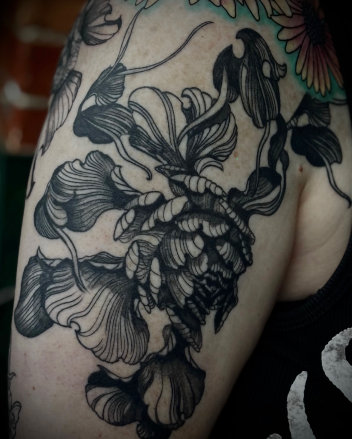 Floral arrangement black and grey tattoo on the shoulder by Tattoos by Marcy