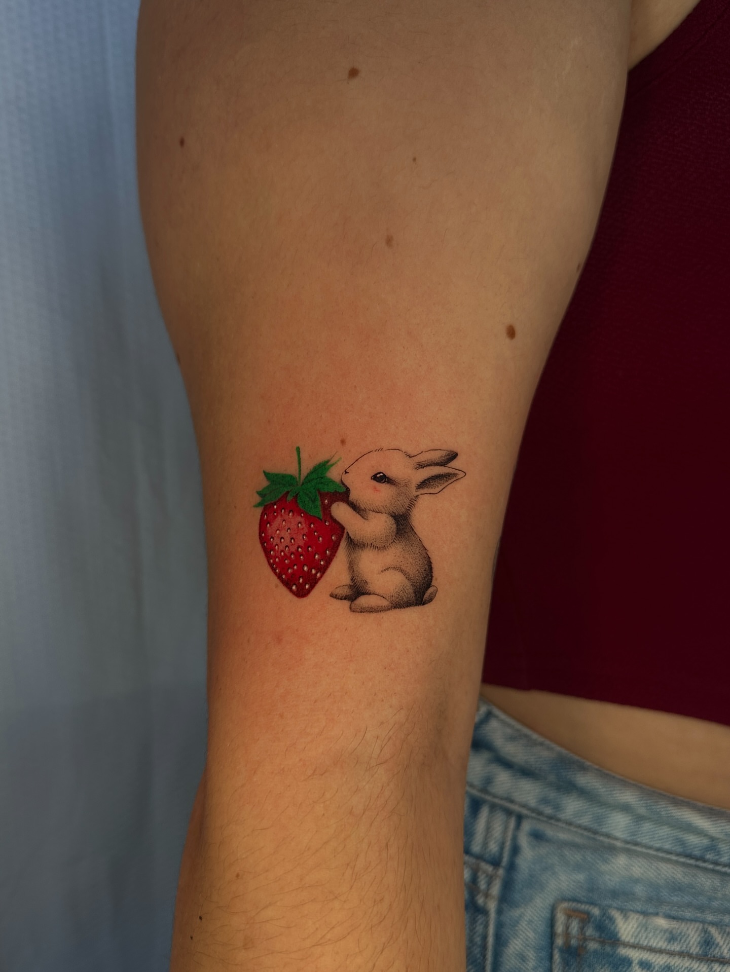 Rabbit and strawberry realism tattoo on the forearm by πΈππππ
