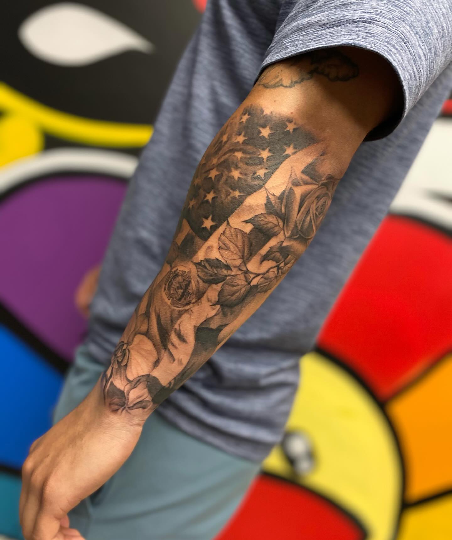American flag and roses black and grey tattoo on the forearm by Antonio