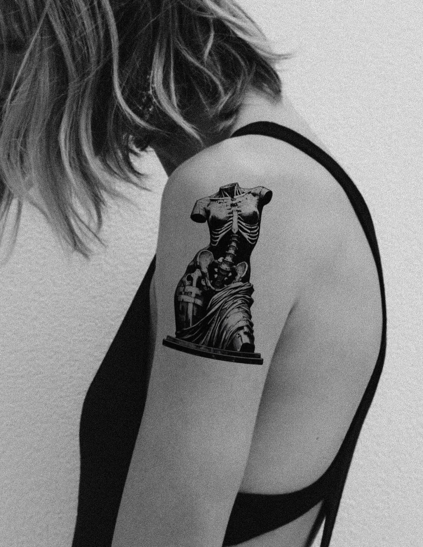 Statue black and grey tattoo on the shoulder by 𝑴𝒆𝒍𝒐