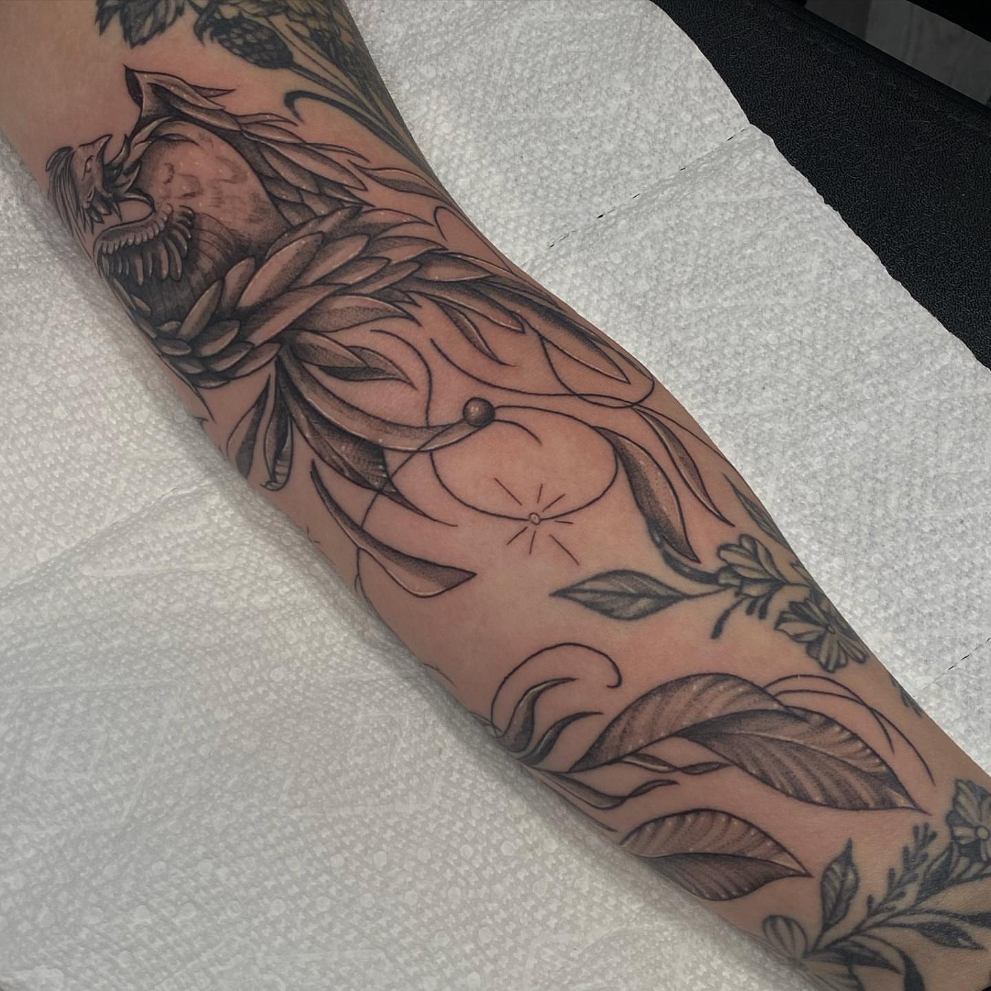 Floral and dragon realism tattoo on the forearm by Maddie Neibert