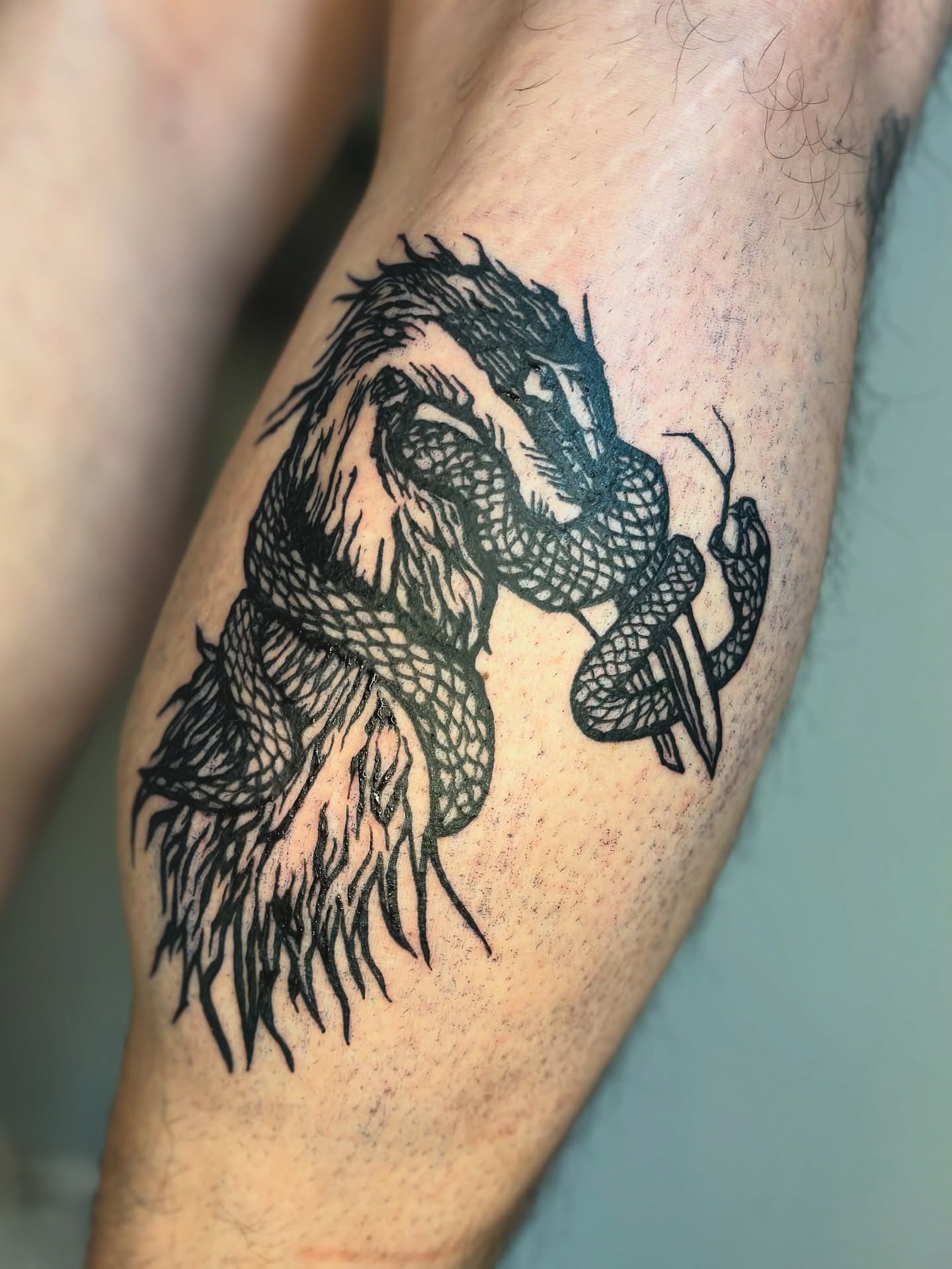 Dragon black and grey tattoo on the forearm by Wren Cavanaugh Tattoos, Seattle, Washington
