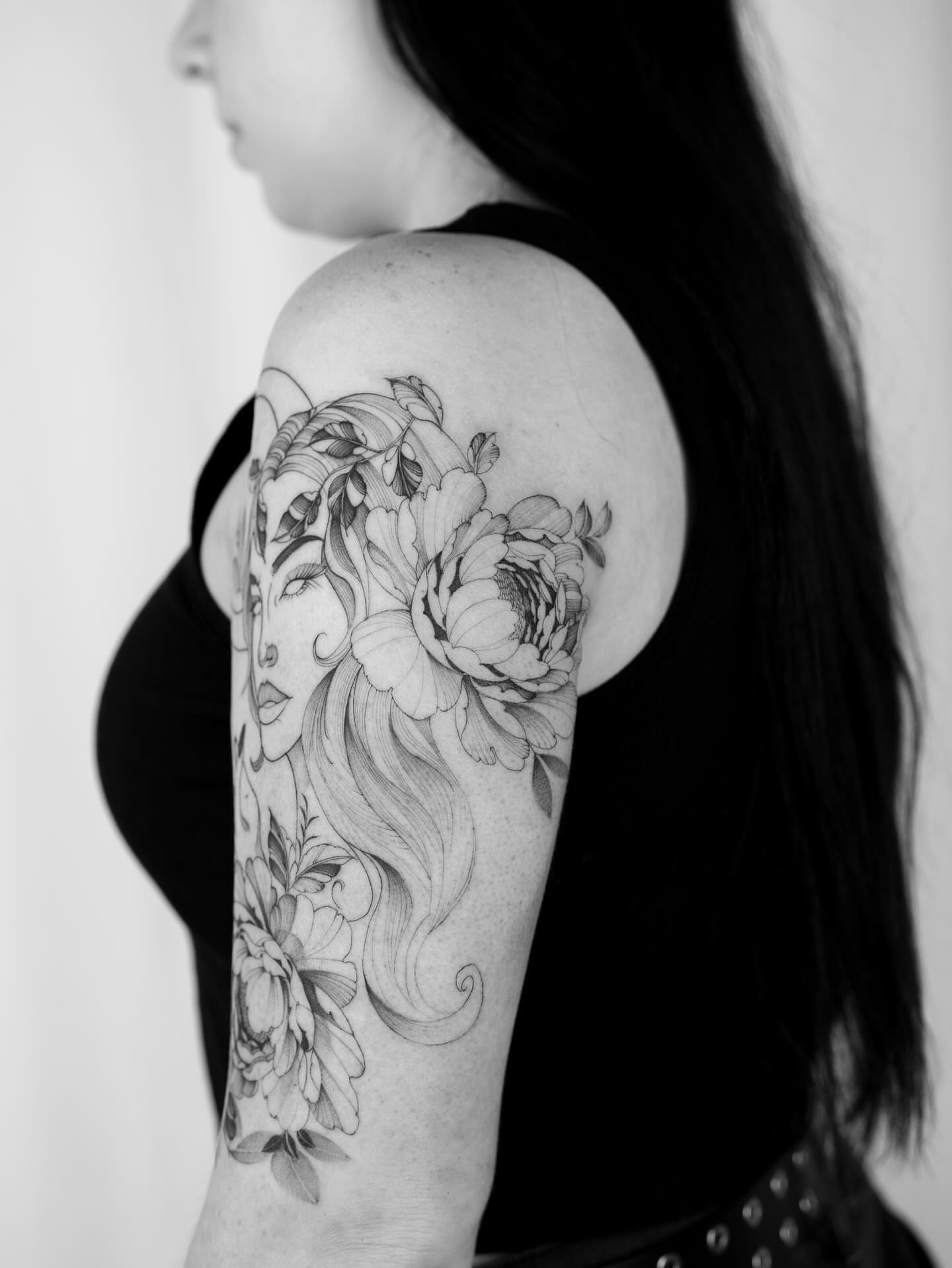 Floral woman realism tattoo on the upper arm by Leo Gao