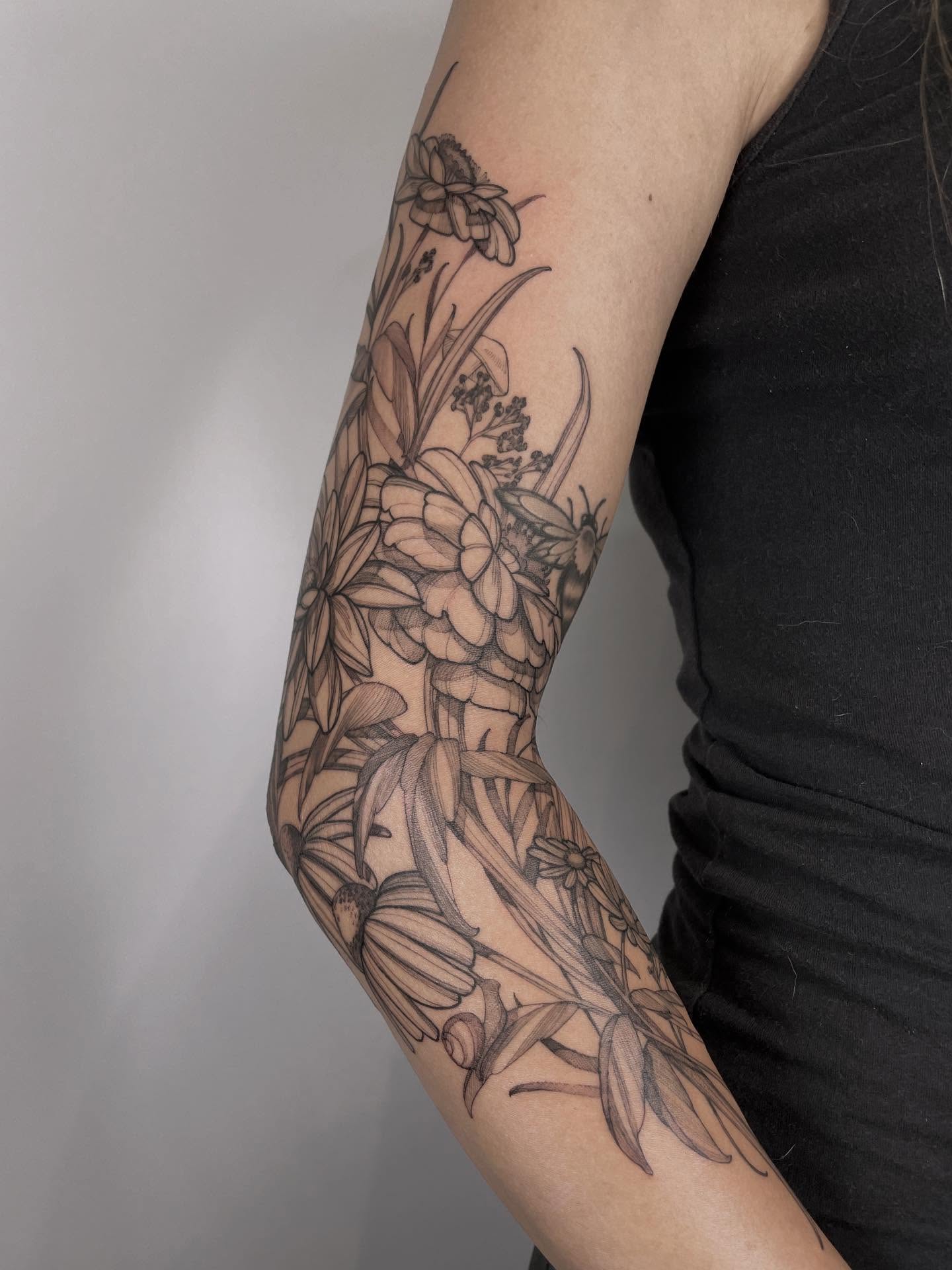 Floral arrangement black and grey tattoo on the forearm by Carol Jacky