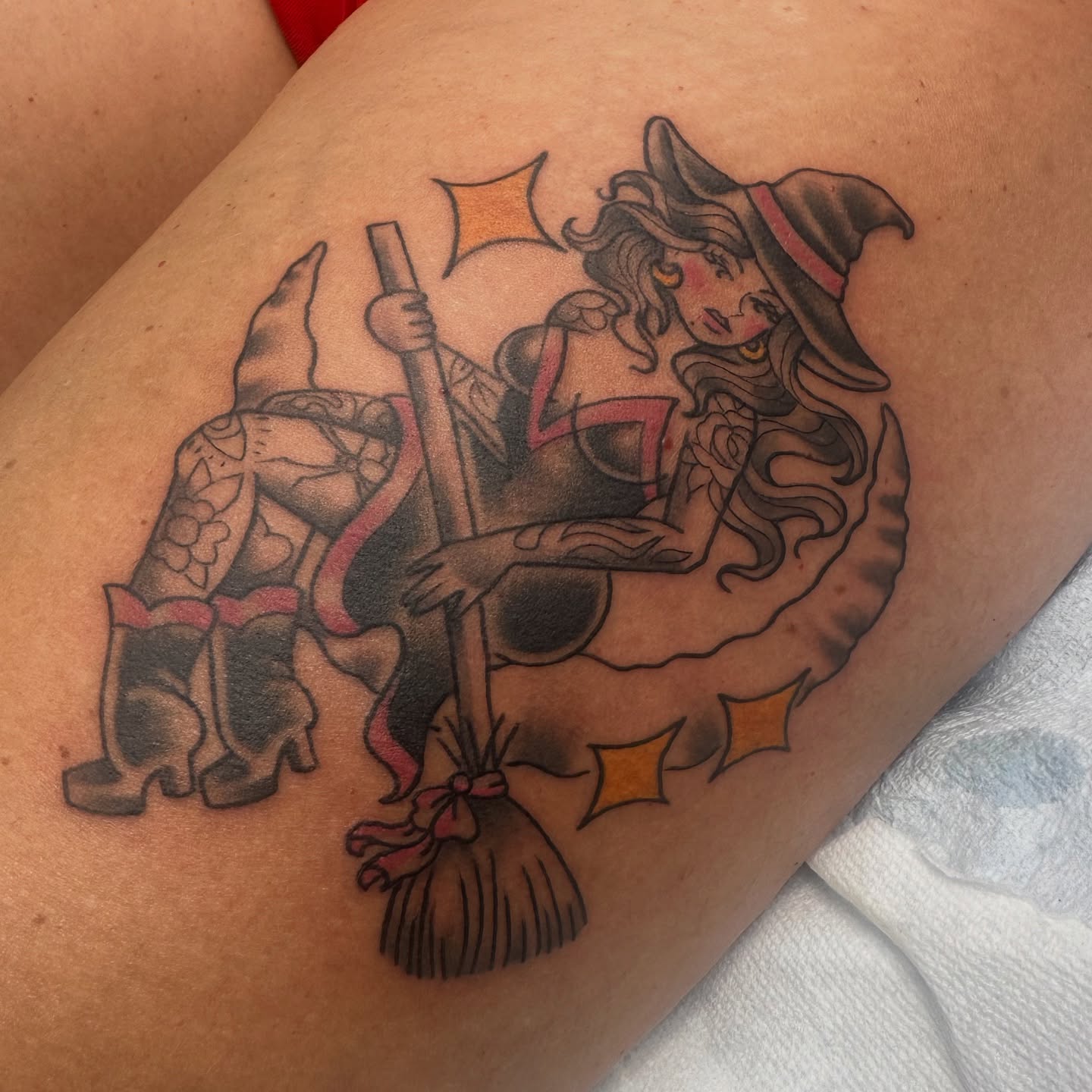 Witch riding a broom American traditional tattoo on the thigh by Heather Cherish