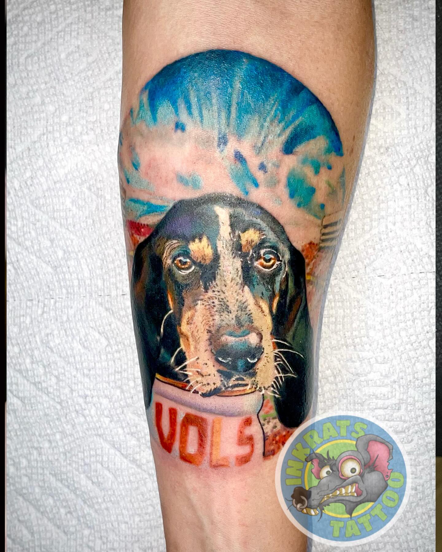 Dog wearing jersey realism tattoo on the forearm by Chadrick Gregory