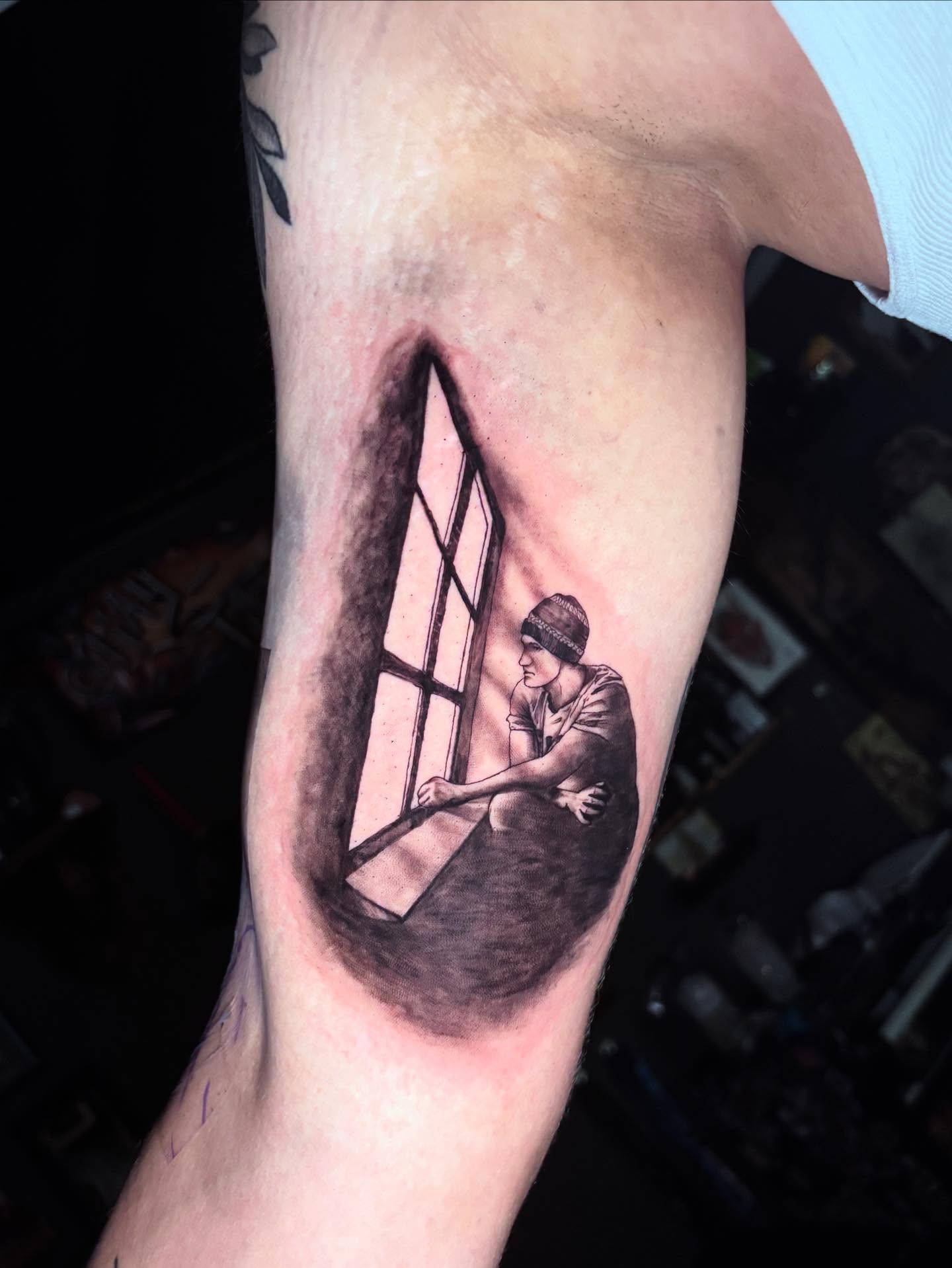 Man looking through window realism tattoo on the forearm by Kayla