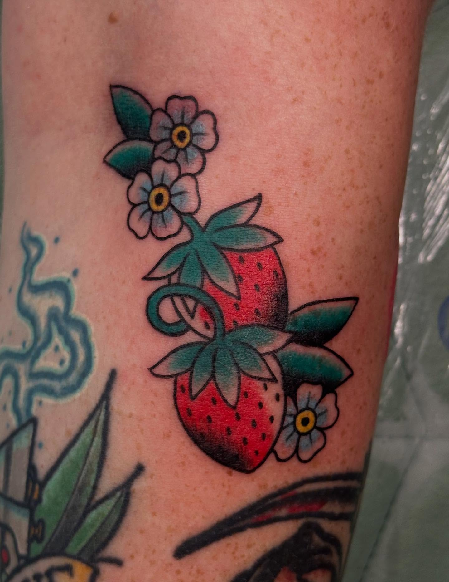 Strawberry and flowers American traditional tattoo on the forearm by Sammy Beresford