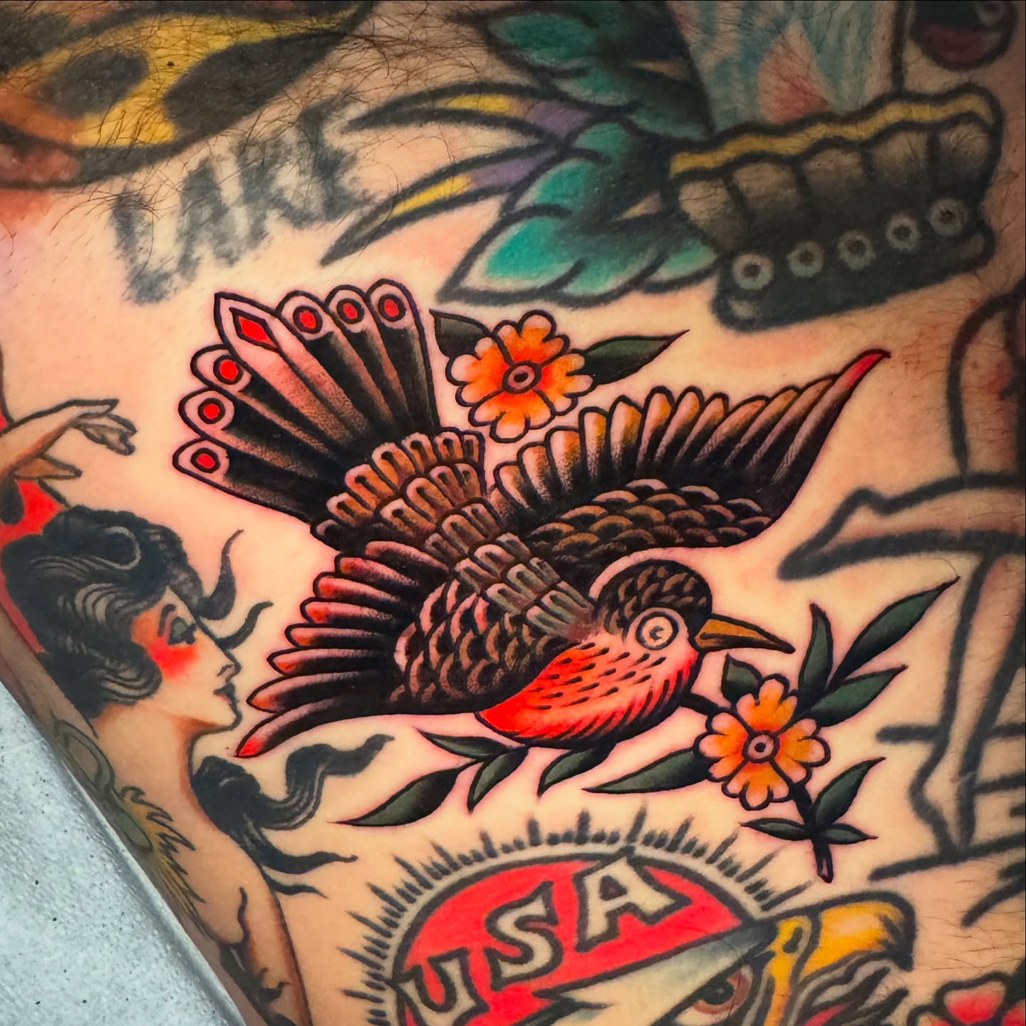 Bird and flowers American traditional tattoo on the upper arm by Pavel