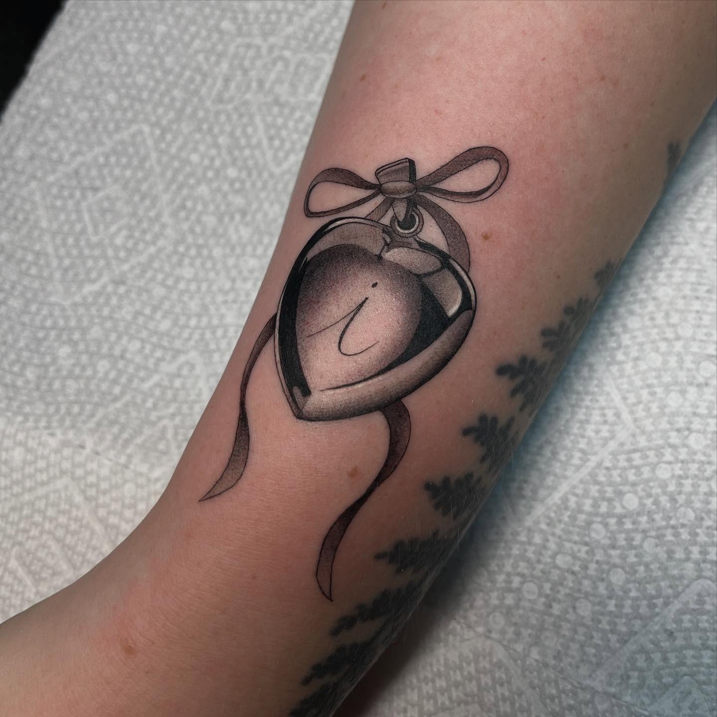 Bell black and grey tattoo on the forearm by Kayla Faircloth, Charlotte, North Carolina