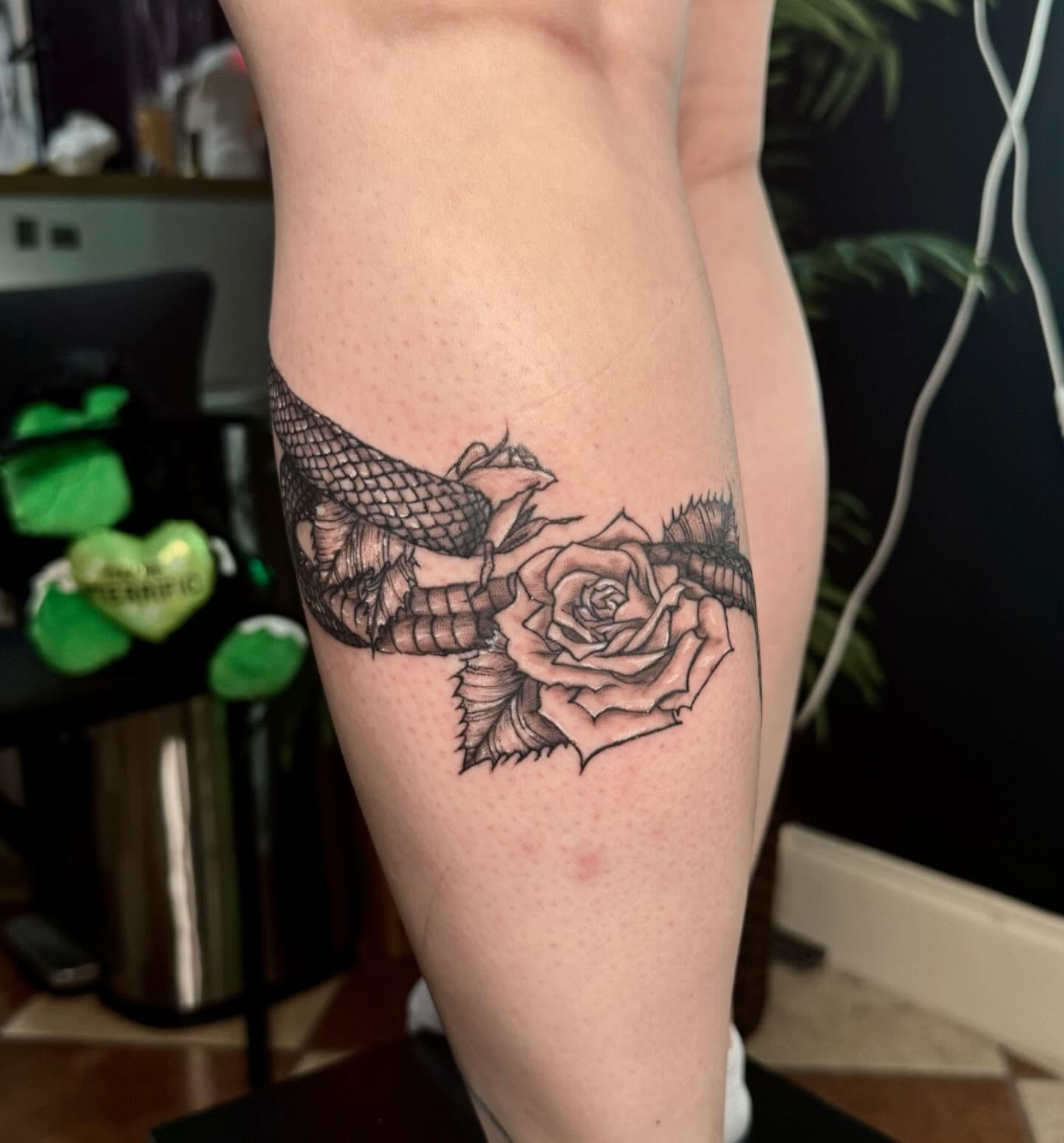 Snake and rose black and grey tattoo on the thigh by Nina Rush