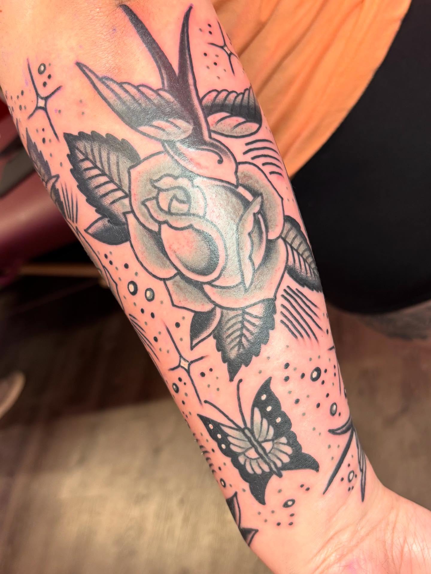 Rose and swallow American traditional tattoo on the forearm by @dannydoestattoos