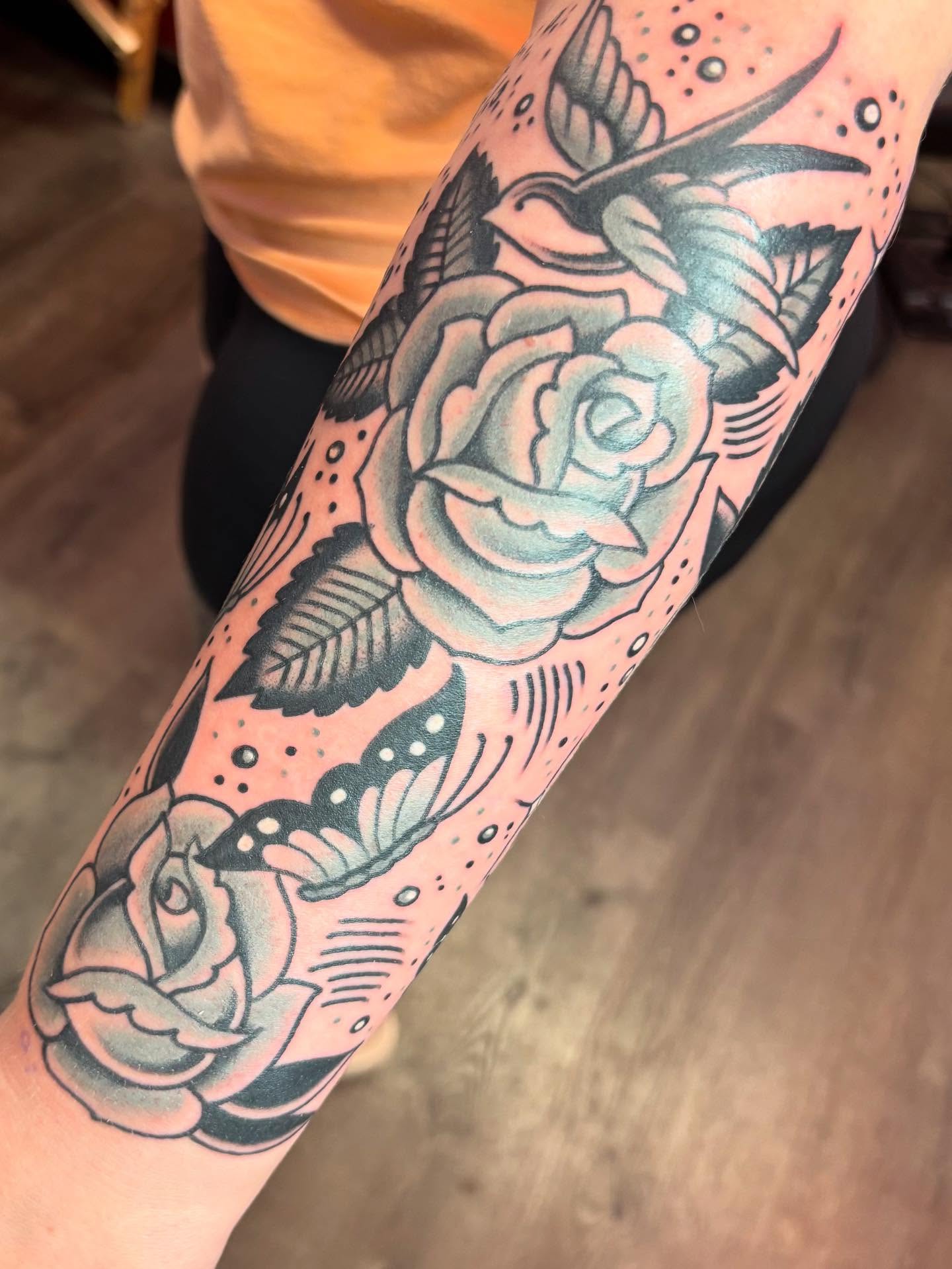 Rose and bird American traditional tattoo on the forearm by @dannydoestattoos