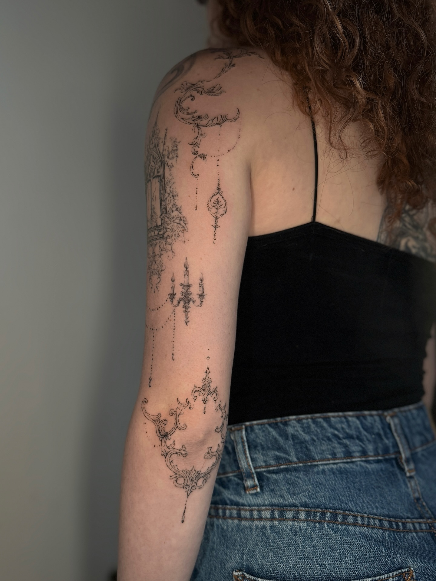 Chandelier black and grey tattoo on the upper arm by Cybersigilism & Fineline Blackwork