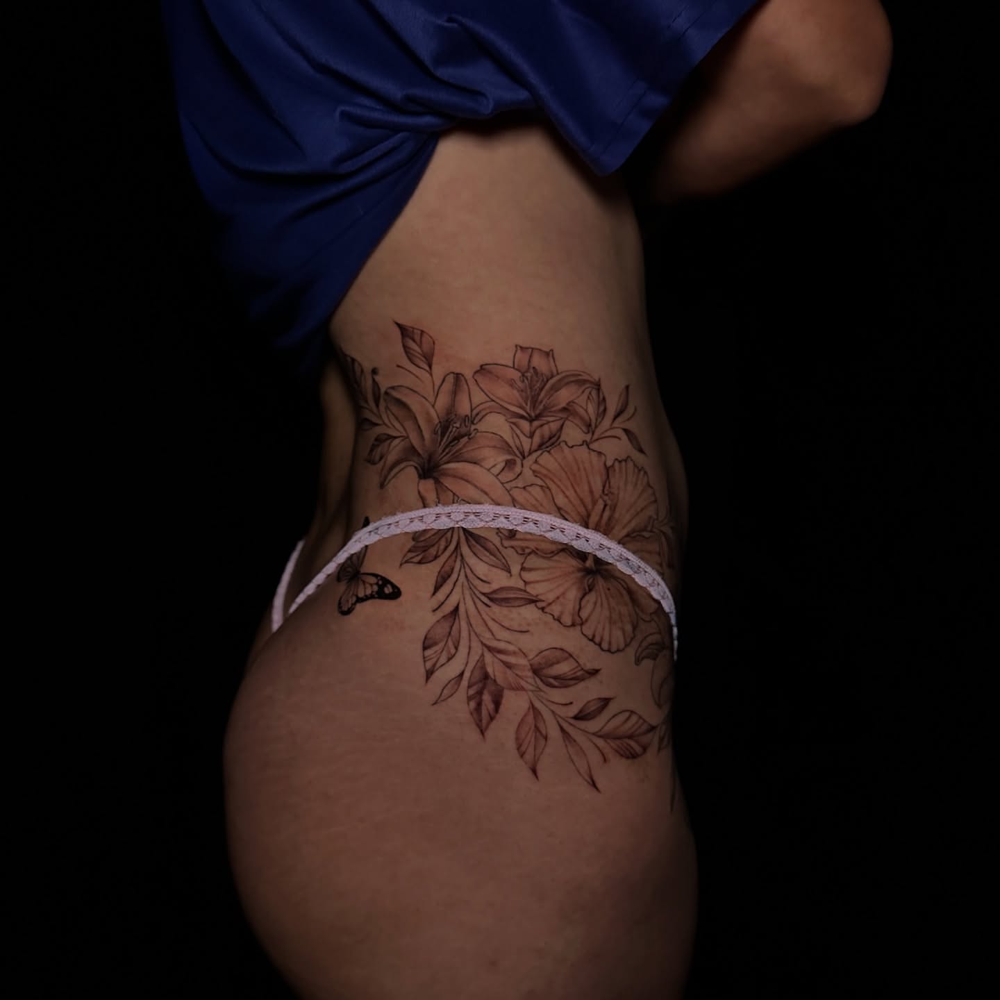 Floral arrangement black and grey tattoo on the thigh by Dani B.