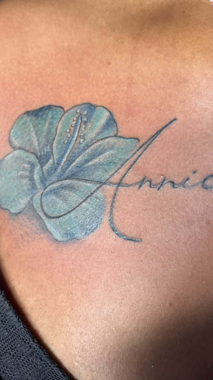 Flower and name tattoo tattoo on the upper arm by Teddi James, Renton, Washington