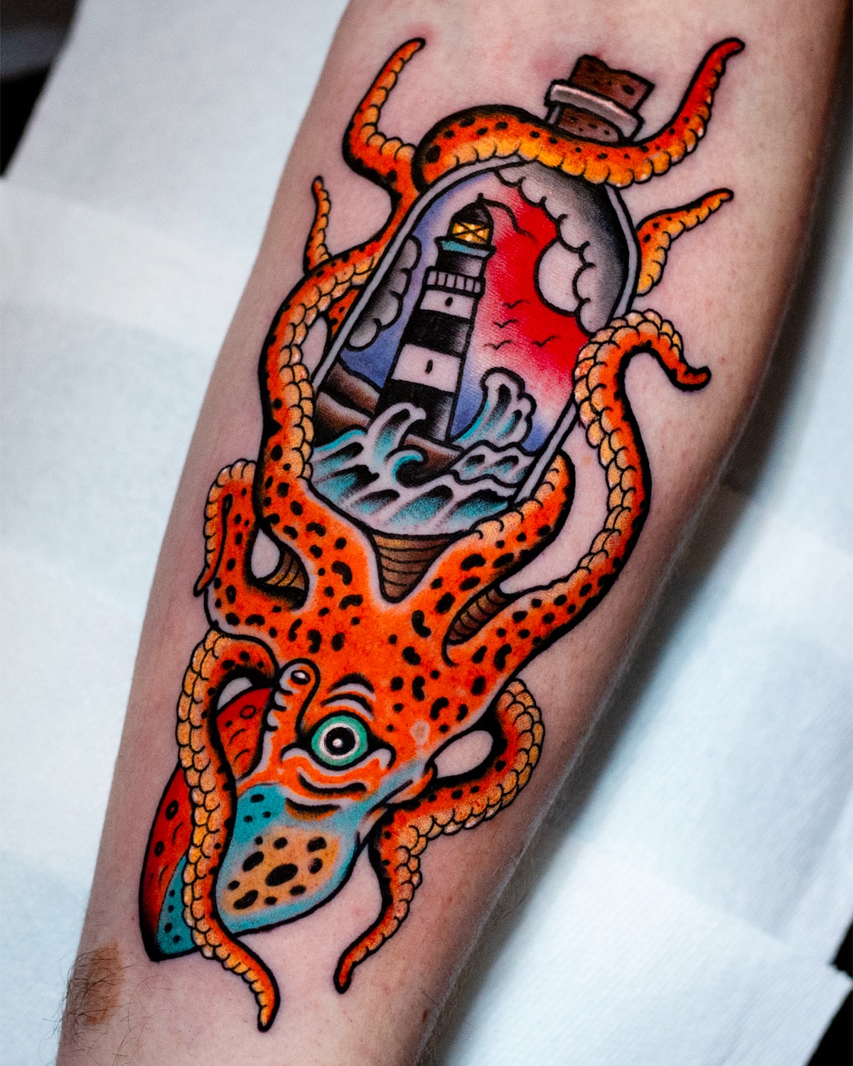 Octopus with lighthouse American traditional tattoo on the forearm by Miguel Comin
