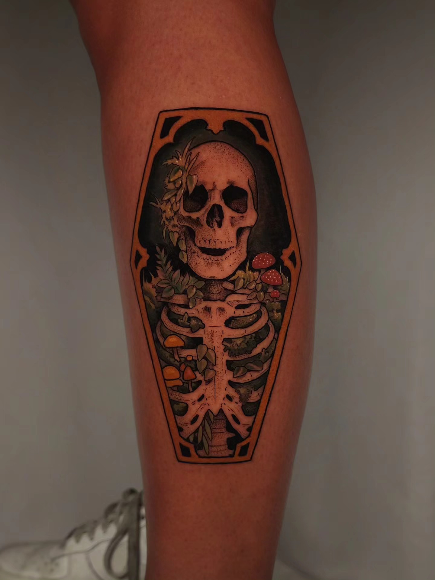 Coffin with skeleton American traditional tattoo on the calf by Whitney Caskey