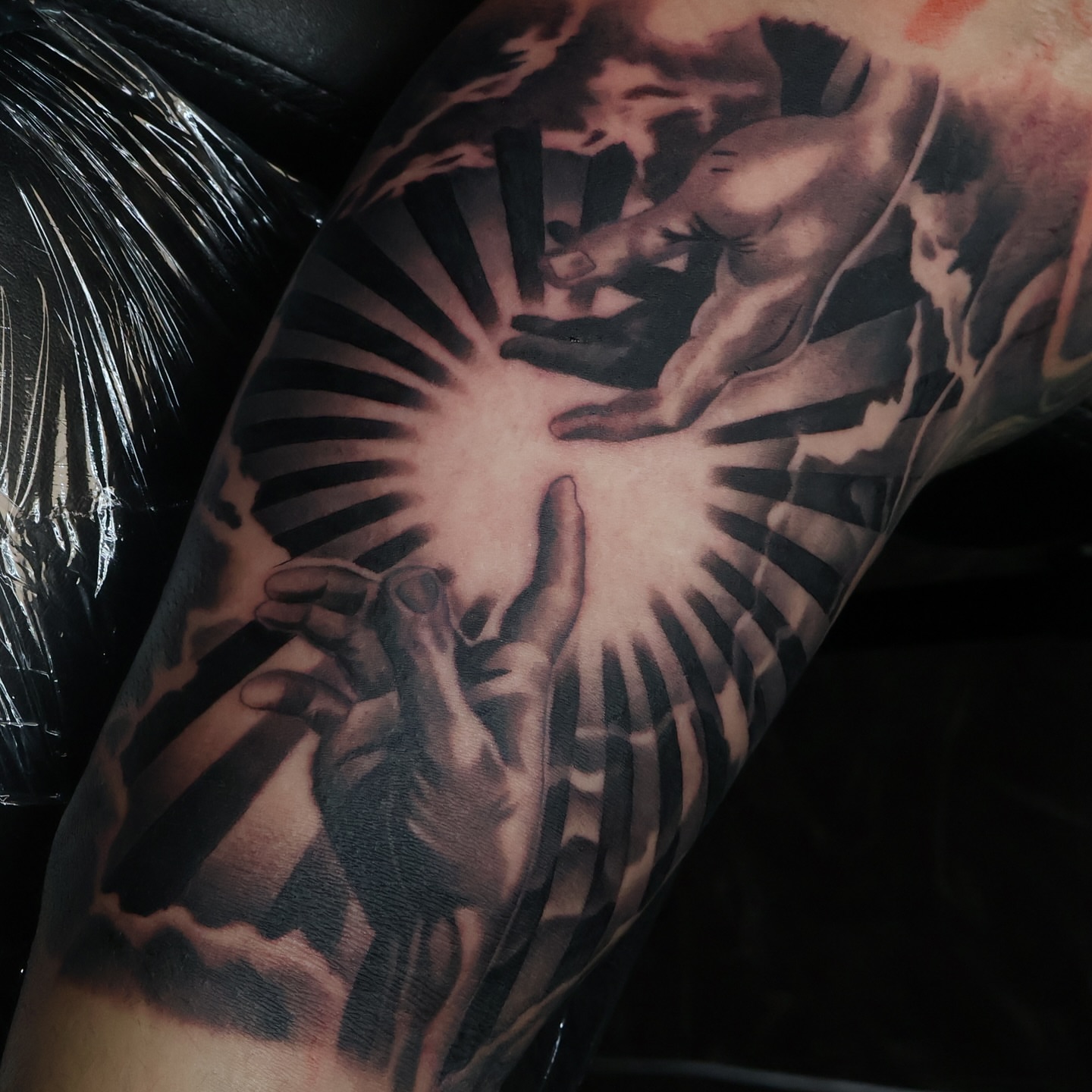 Hands reaching towards light realism tattoo on the forearm by Angels tattoo