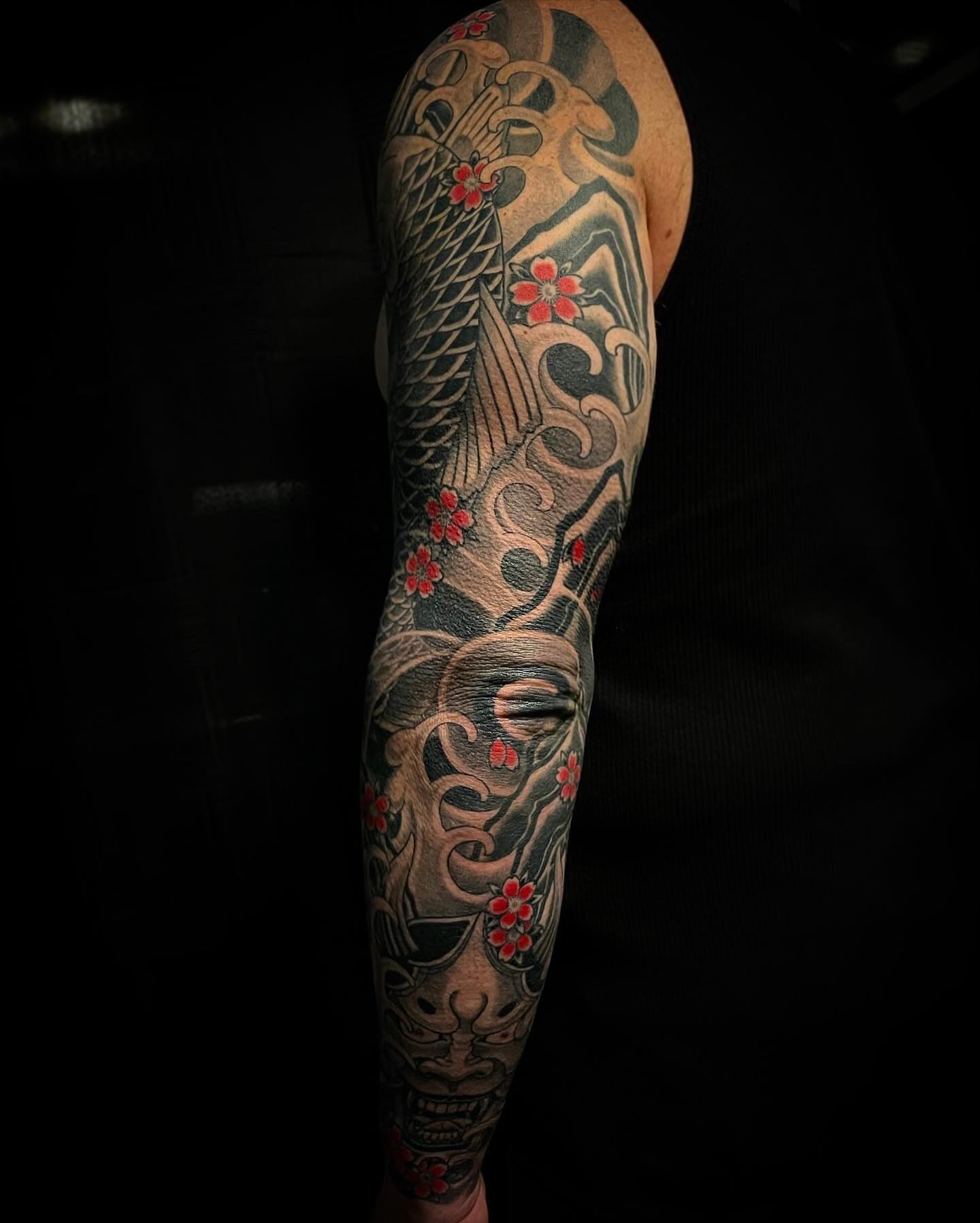 Koi fish and mask japanese irezumi tattoo on the forearm by Jacob Finelli