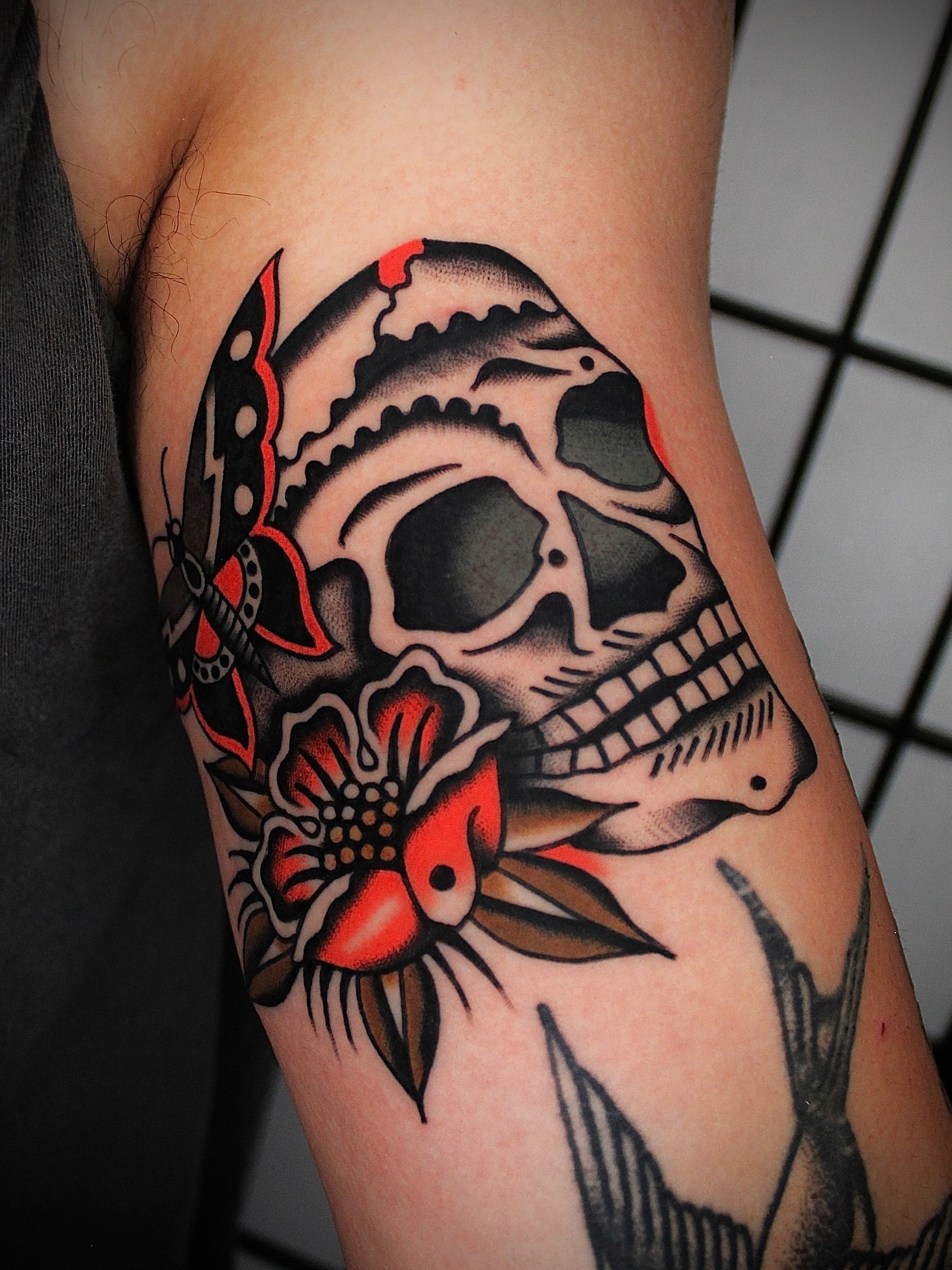 Skull and flower American traditional tattoo on the forearm by Dustin Stemen, Charlotte, North Carolina