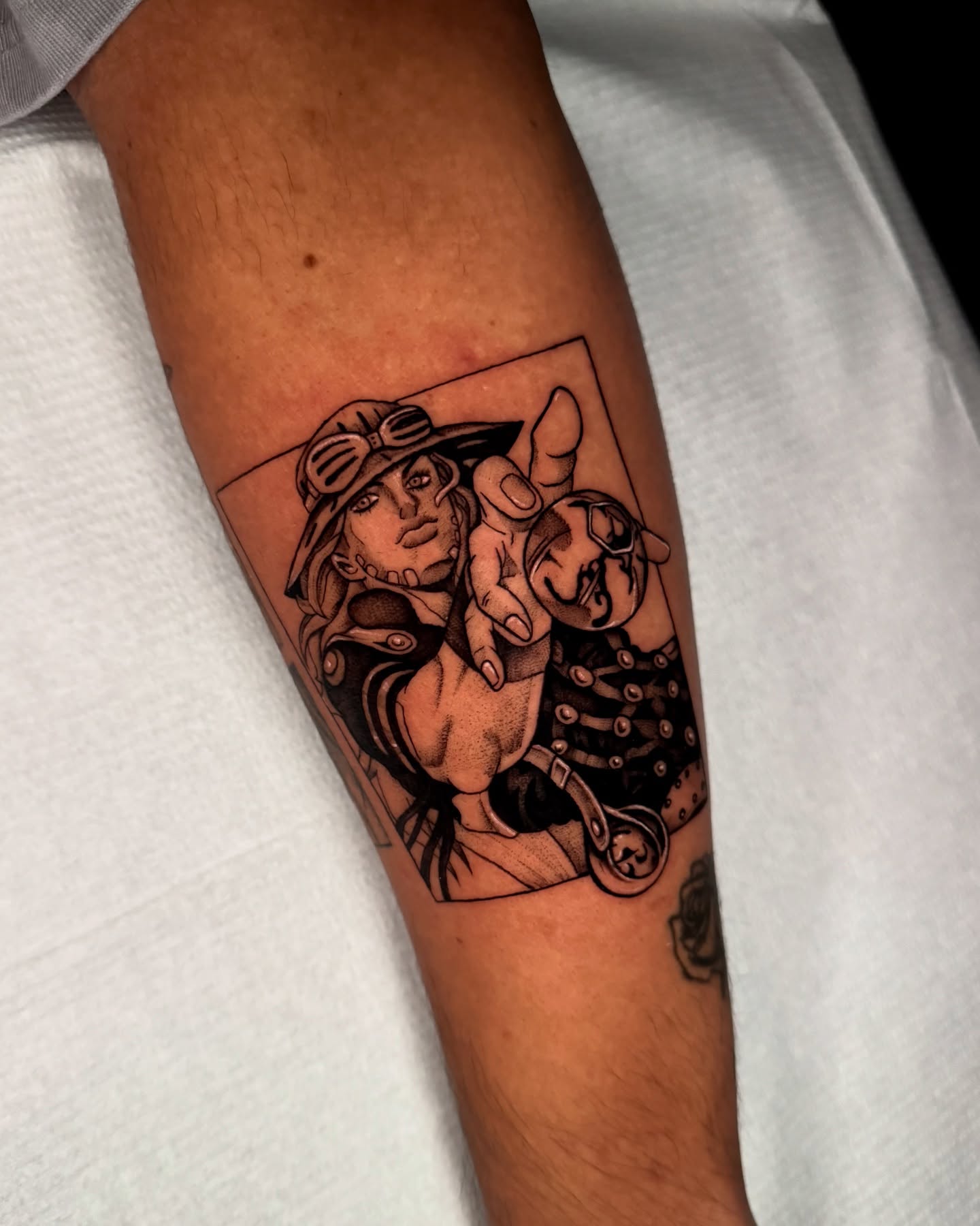 Manga character black and grey tattoo on the forearm by kelsey hackett