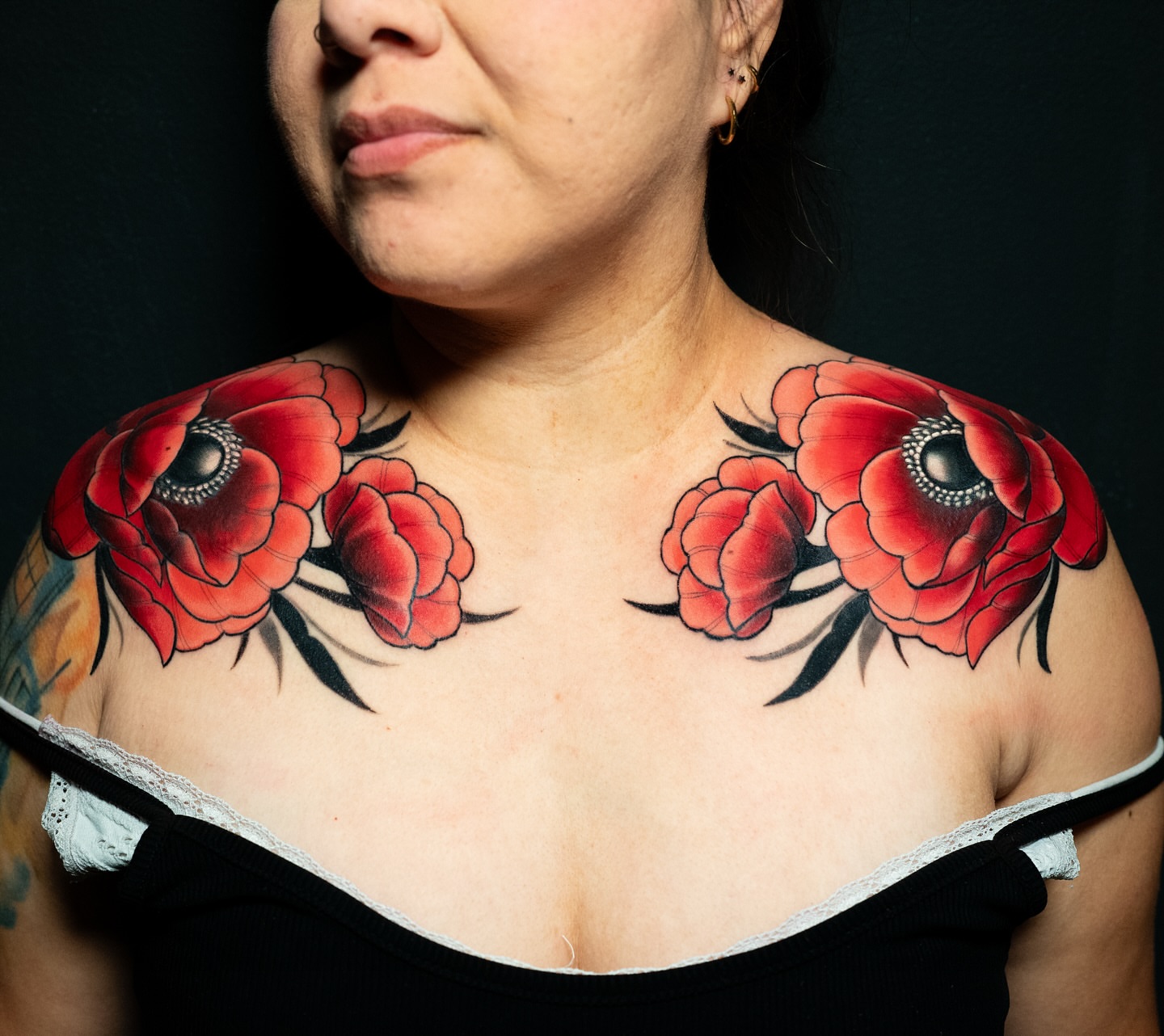 Red poppies American traditional tattoo on the chest by Alonzo Villa Tattoo