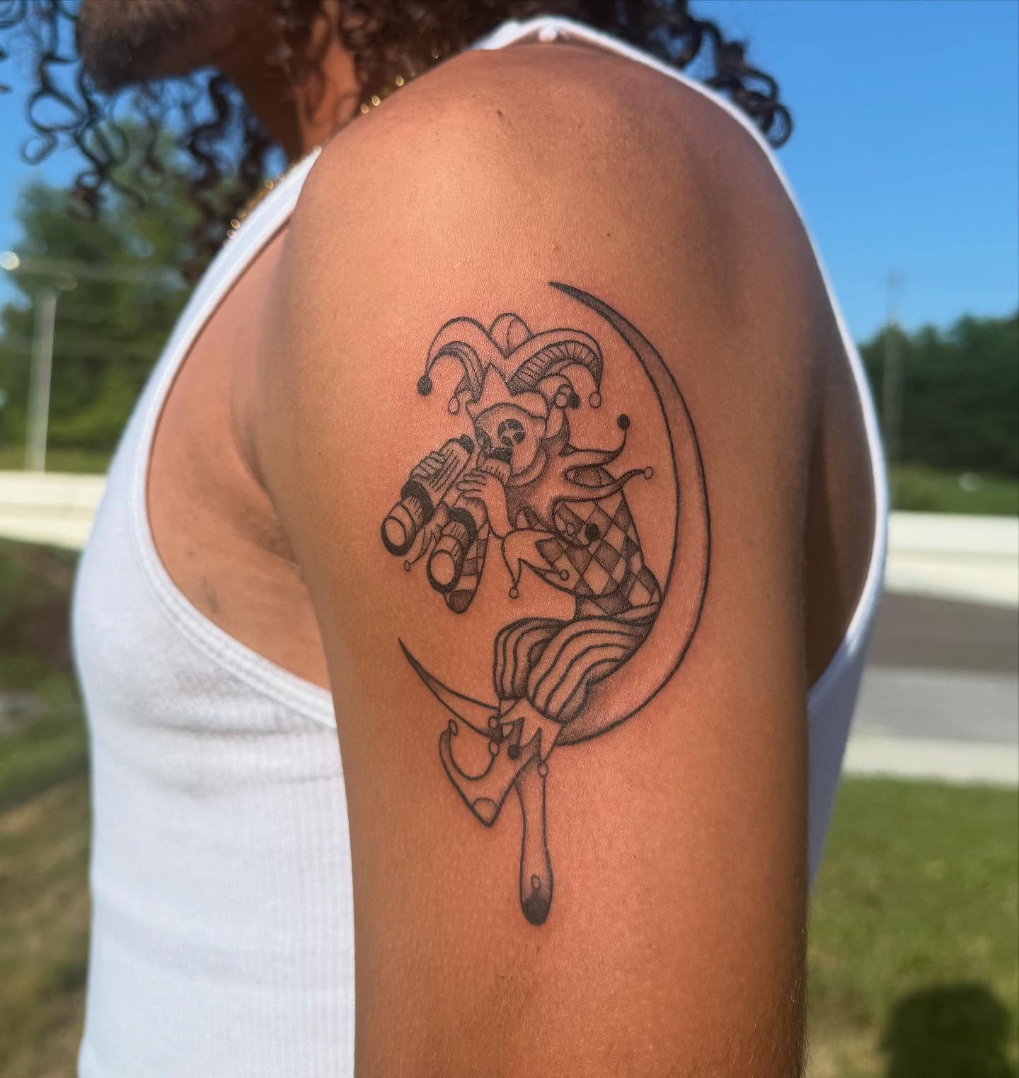 Jester and skull black and grey tattoo on the shoulder by Imani