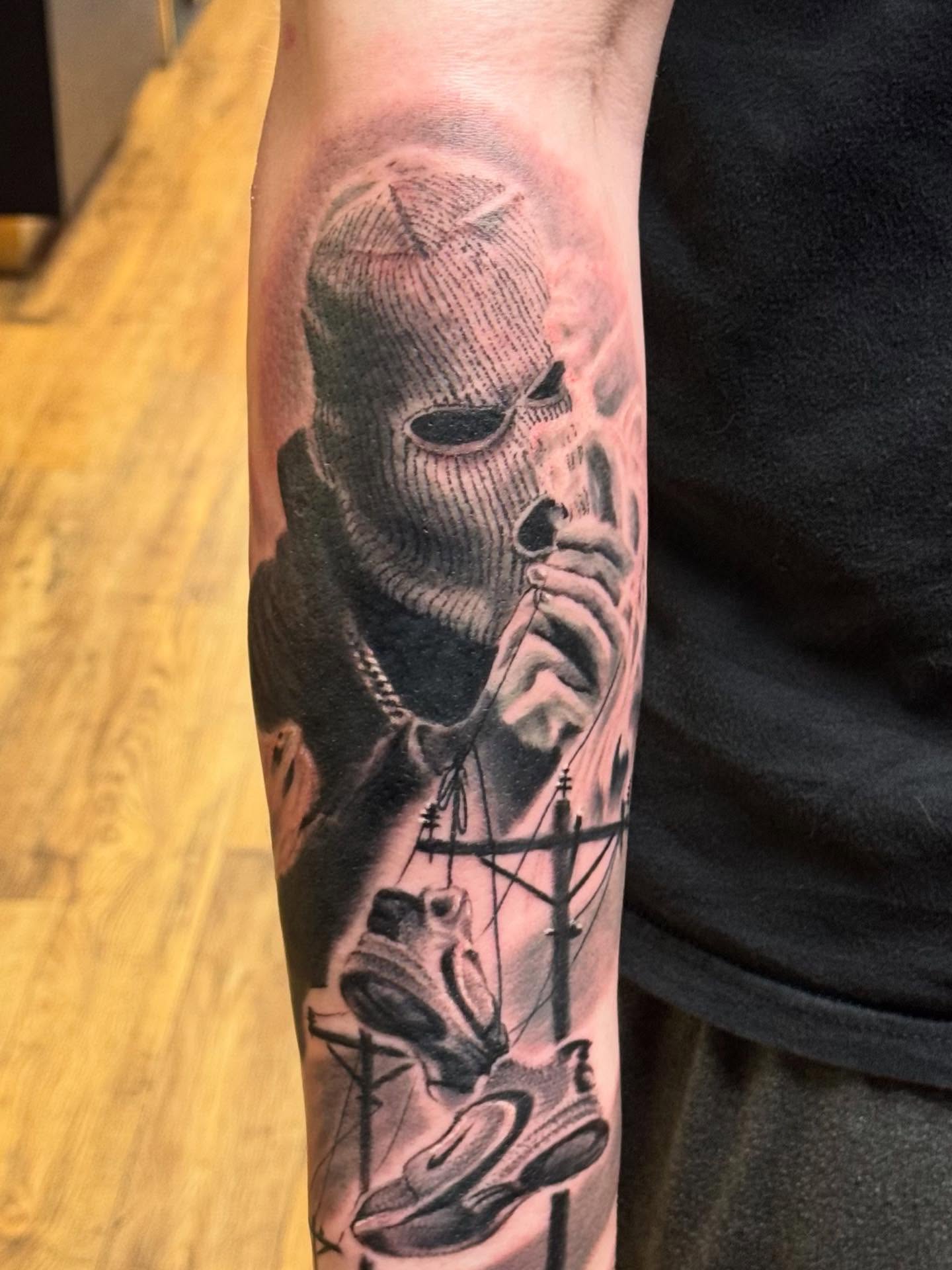 Skull wearing mask realism tattoo on the forearm by Kyle J. Bishop