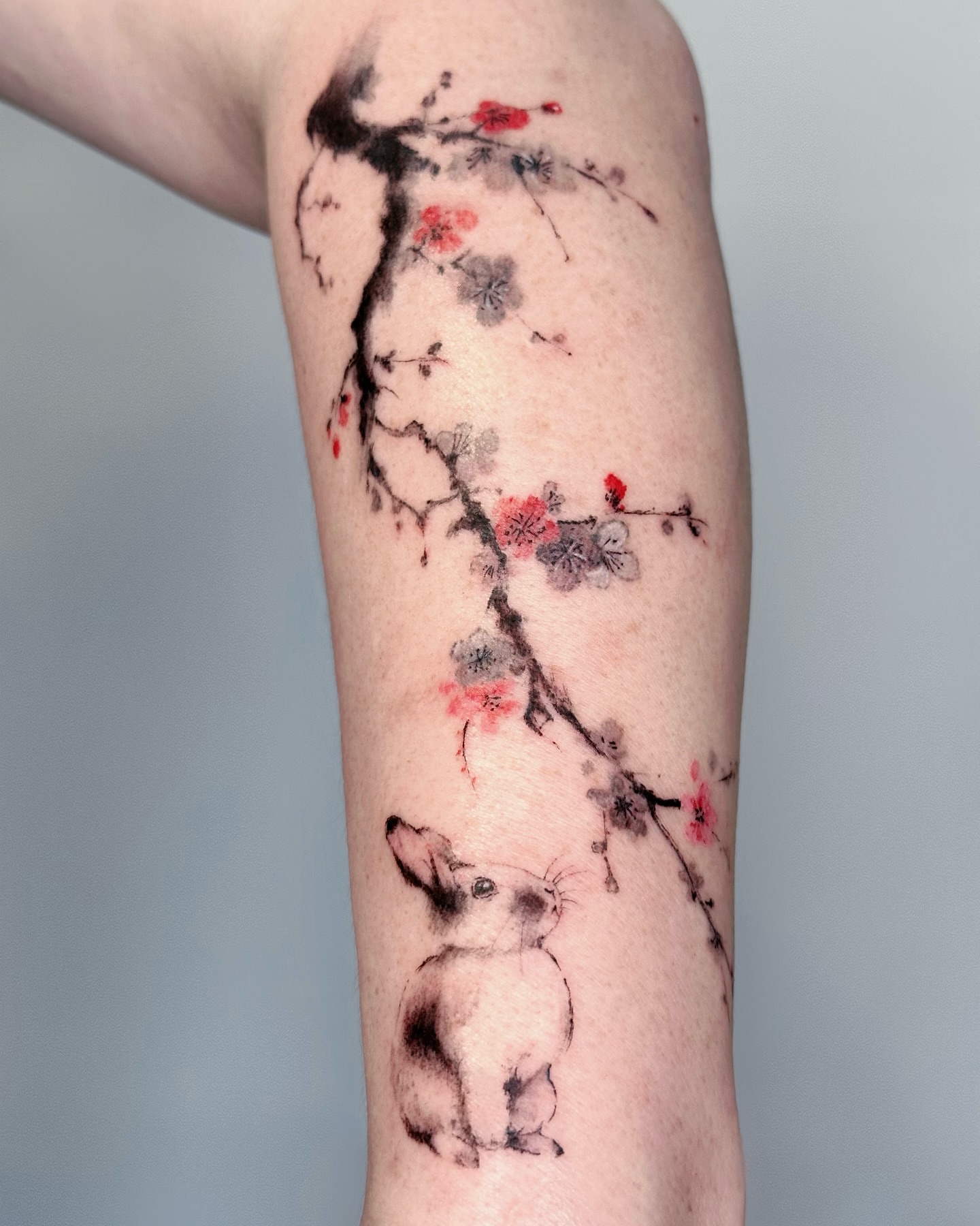 Cherry blossoms and dog watercolor tattoo on the forearm by Sylvia｜思岐, Vancouver, British Columbia