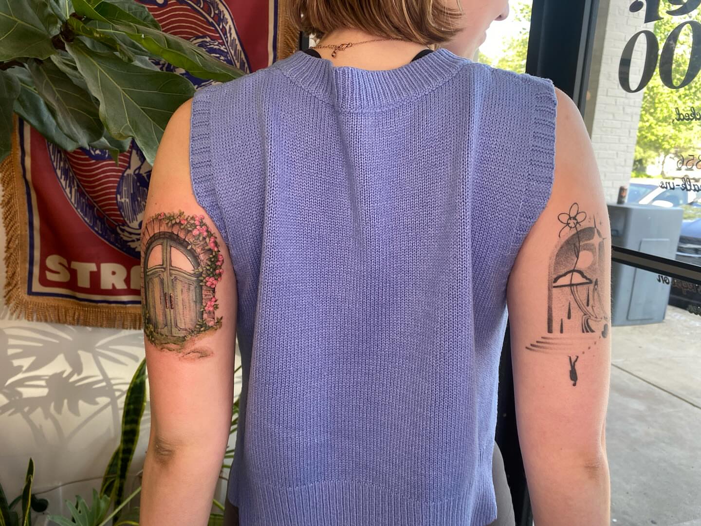 Doorway with flowers realism tattoo on the upper arm by Amber Miracle