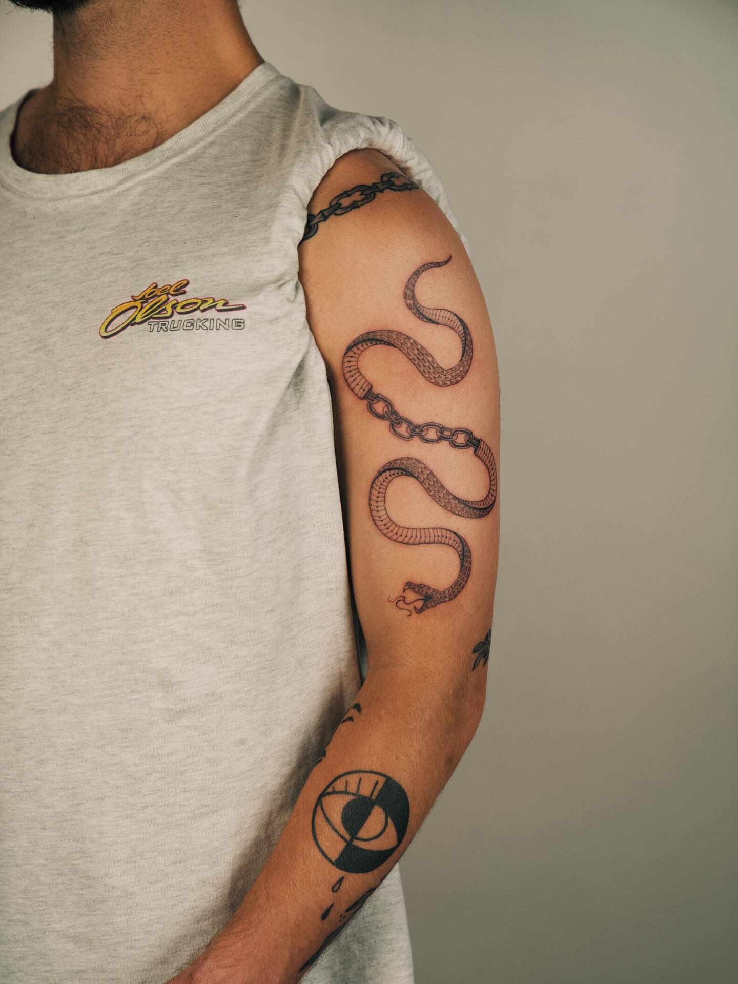 Snake and chain black and grey tattoo on the forearm by b i l l i e, Seattle, Washington