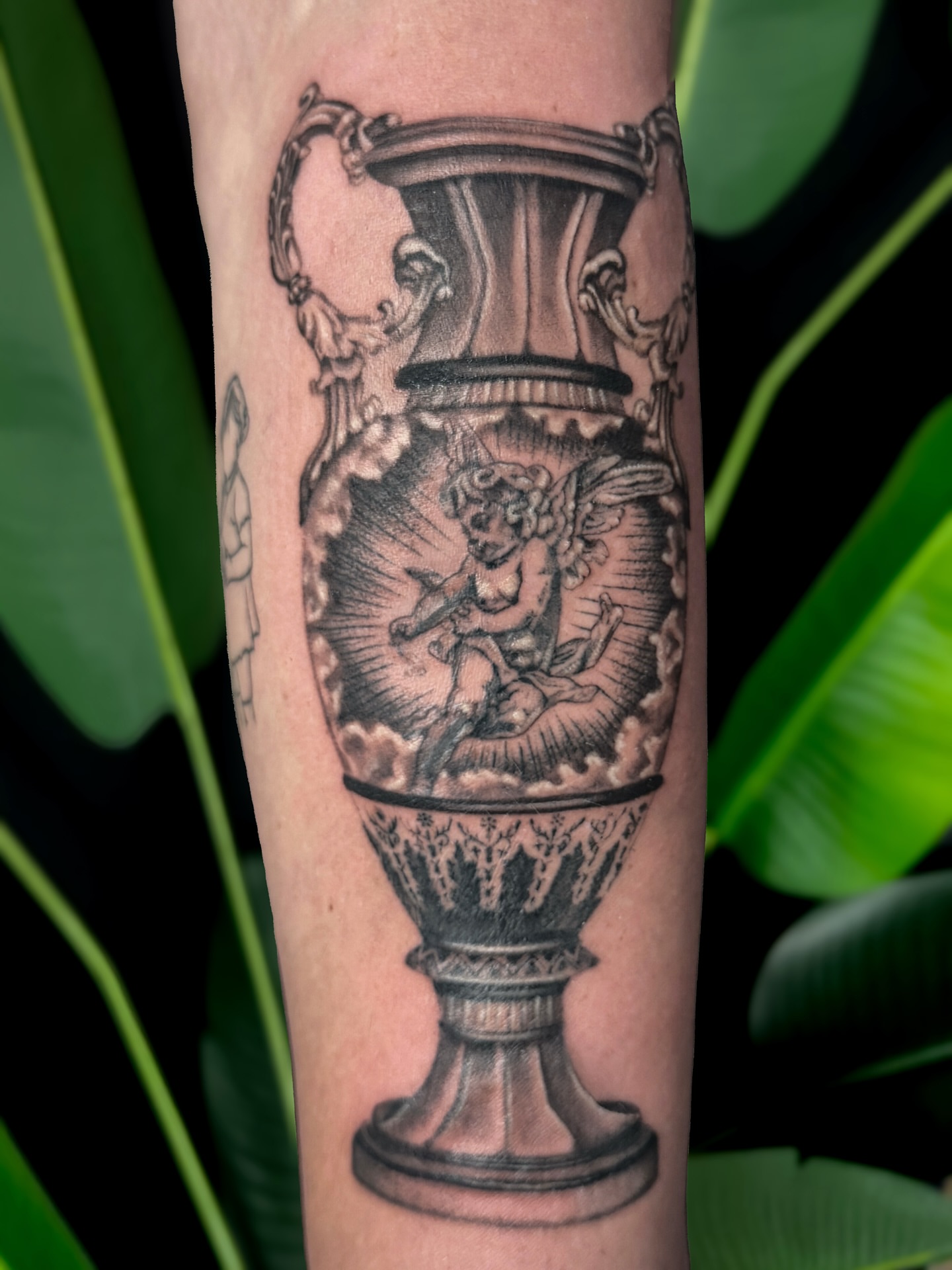 Cherub in urn realism tattoo on the forearm by Jordyn Tinney