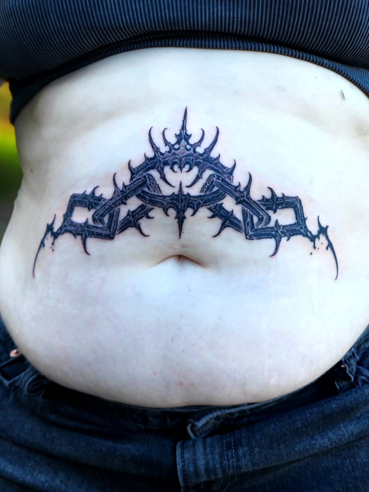 Spiky crown black and grey tattoo on the torso by @hellscribe