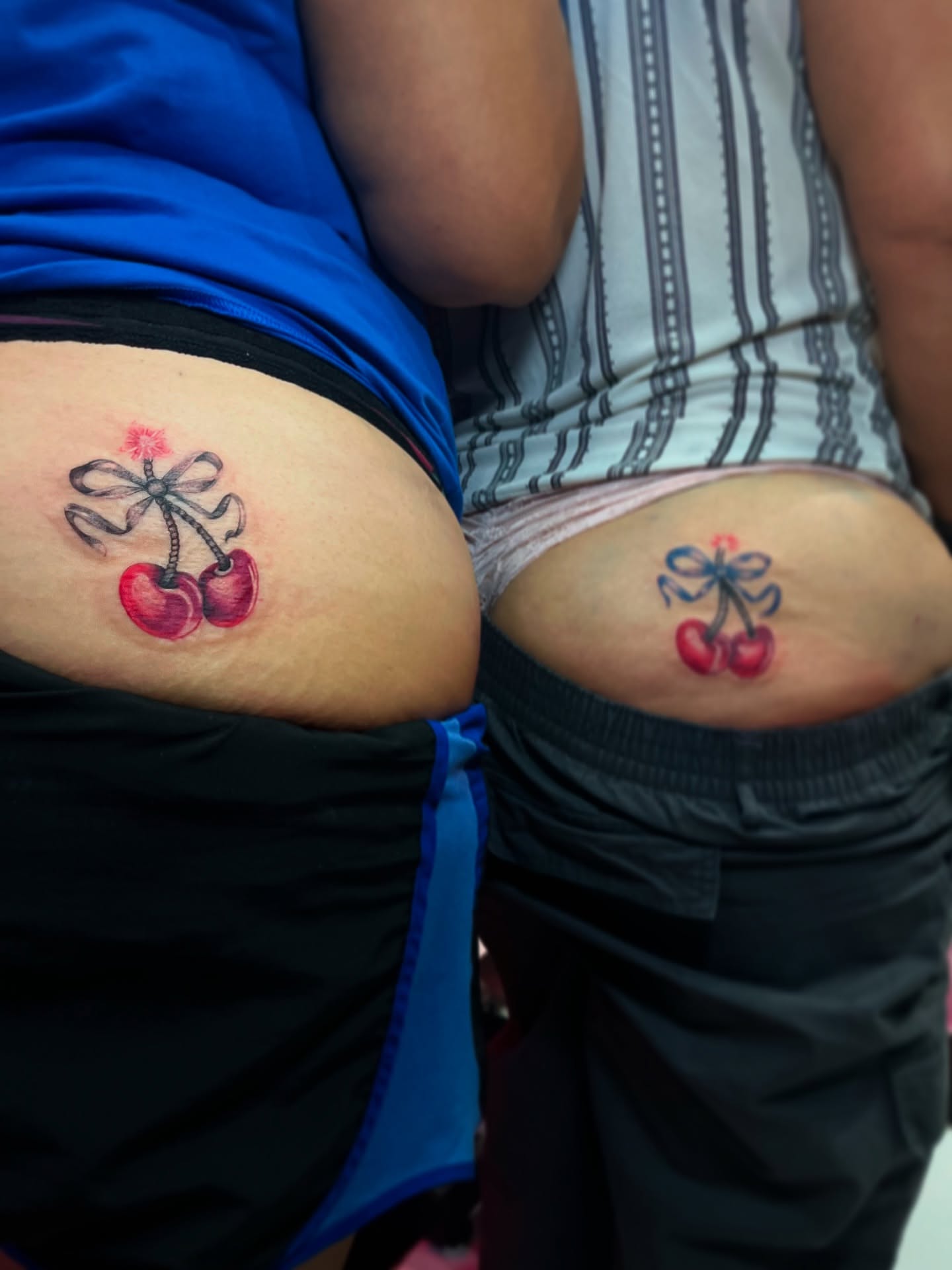 Cherry with bow realism tattoo on the thigh by Christa Martinez