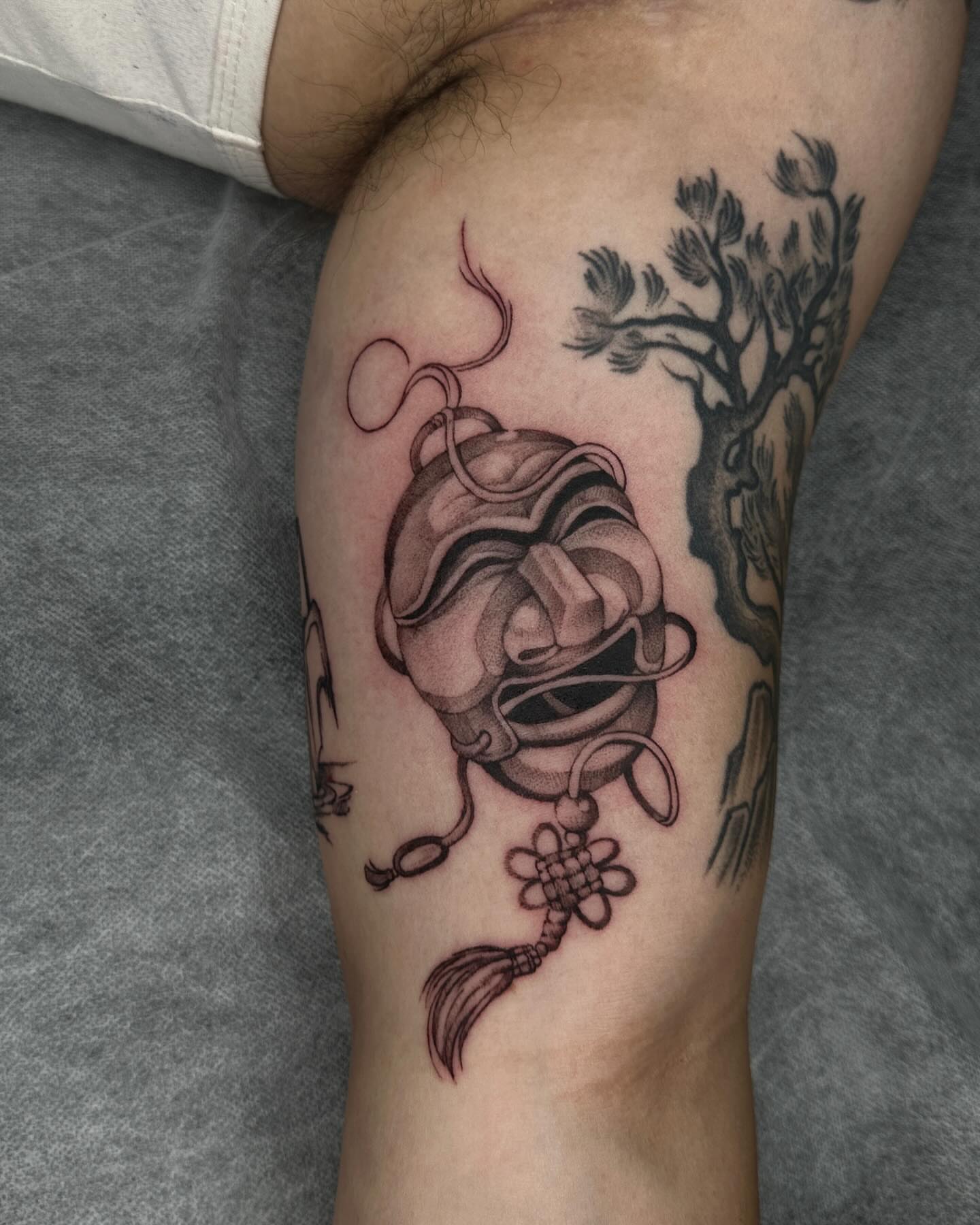 Mask and tree black and grey tattoo on the forearm by A L e X